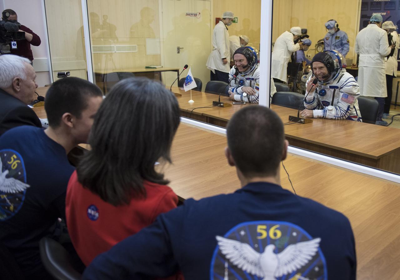 Expedition 55 Soyuz Commander Oleg Artemyev of Roscosmos, left, and flight engineer Drew Feustel of NASA, right, talk with family and friends after having their Russian Sokol suits pressure checked in preparation for launch aboard the Soyuz MS-08 spacecraft, Wednesday, March 21, 2018 at the Baikonur Cosmodrome in Kazakhstan. Artemyev, Feustel, and flight engineer Ricky Arnold of NASA launched aboard the Soyuz MS-08 spacecraft at 1:44 p.m. Eastern time (11:44 p.m. Baikonur time) on March 21 to begin their journey to the International Space Station.  Photo Credit: (NASA/Joel Kowsky)