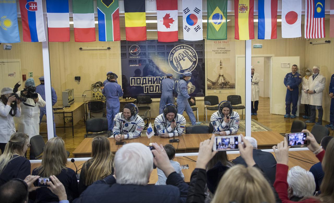 Expedition 55 flight engineer Ricky Arnold of NASA, left, Soyuz Commander Oleg Artemyev of Roscosmos, center, and flight engineer Drew Feustel of NASA, right, talk with family and friends after having their Russian Sokol suits pressure checked in preparation for launch aboard the Soyuz MS-08 spacecraft, Wednesday, March 21, 2018 at the Baikonur Cosmodrome in Kazakhstan. Arnold, Artemyev, and Feustel launched aboard the Soyuz MS-08 spacecraft at 1:44 p.m. Eastern time (11:44 p.m. Baikonur time) on March 21 to begin their journey to the International Space Station.  Photo Credit: (NASA/Joel Kowsky)