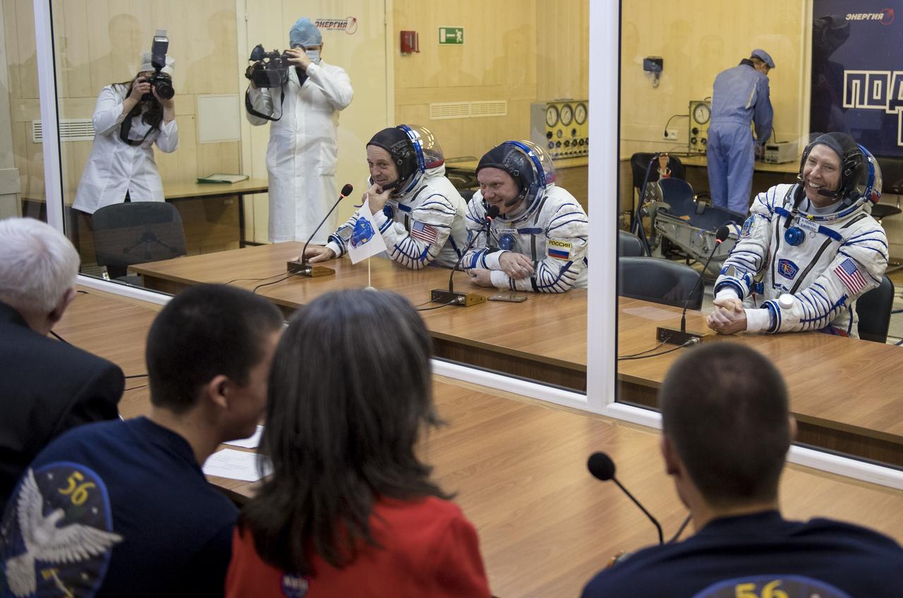 Expedition 55 flight engineer Ricky Arnold of NASA, left, Soyuz Commander Oleg Artemyev of Roscosmos, center, and flight engineer Drew Feustel of NASA, right, talk with family and friends after having their Russian Sokol suits pressure checked in preparation for launch aboard the Soyuz MS-08 spacecraft, Wednesday, March 21, 2018 at the Baikonur Cosmodrome in Kazakhstan. Arnold, Artemyev, and Feustel launched aboard the Soyuz MS-08 spacecraft at 1:44 p.m. Eastern time (11:44 p.m. Baikonur time) on March 21 to begin their journey to the International Space Station.  Photo Credit: (NASA/Joel Kowsky)