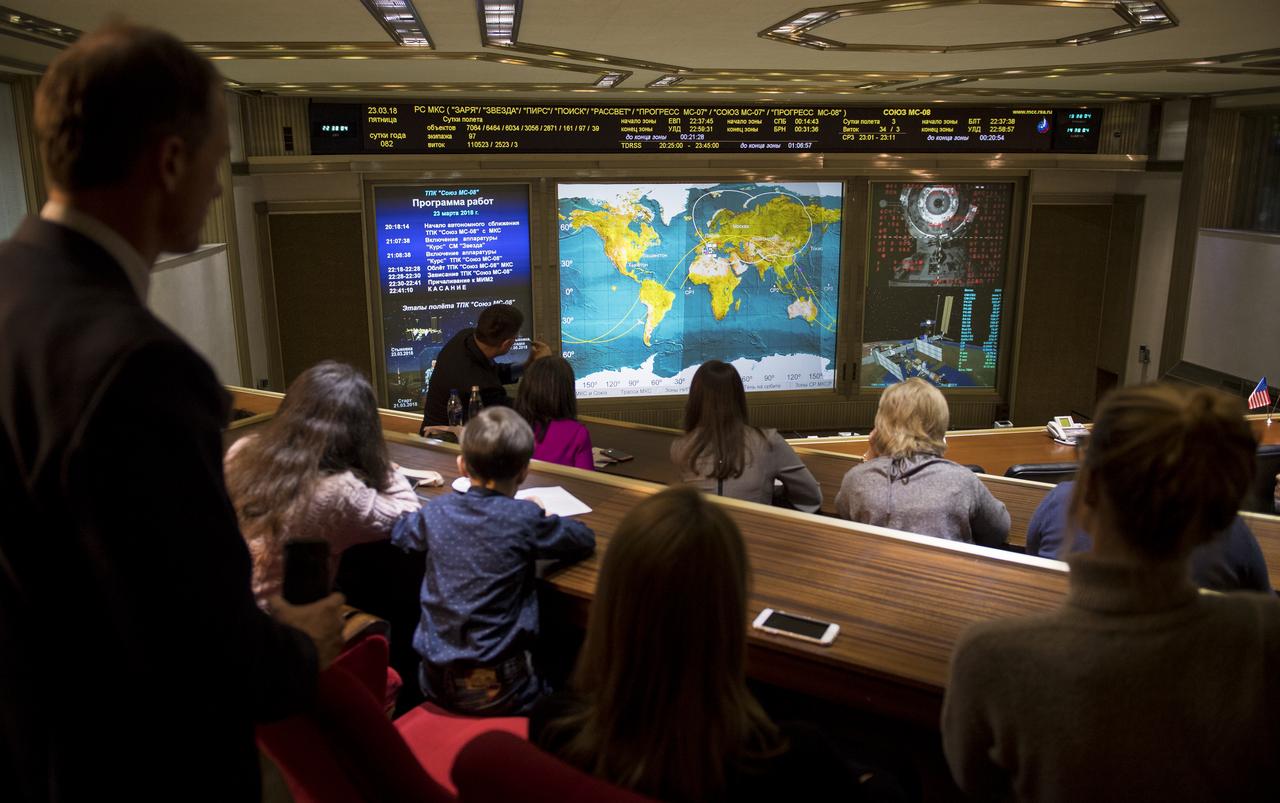 Friends and family members of the Soyuz MS-08 crew watch a live view of the International Space Station, as seen by cameras onboard the spacecraft with Expedition 55-56 crewmembers Oleg Artemyev of Roscosmos and Ricky Arnold and Drew Feustel of NASA, on screens at the Moscow Mission Control Center as the spacecraft approaches for docking, Friday, March 23, 2018 in Korolev, Russia. The Soyuz MS-08 spacecraft carrying Artemyev, Feustel, and Arnold docked at 3:40 p.m. Eastern time (10:40 p.m. Moscow time) and joined Expedition 55 Commander Anton Shkaplerov of Roscosmos, Scott Tingle of NASA, and Norishige Kanai of the Japan Aerospace Exploration Agency (JAXA). Photo Credit: (NASA/Joel Kowsky)