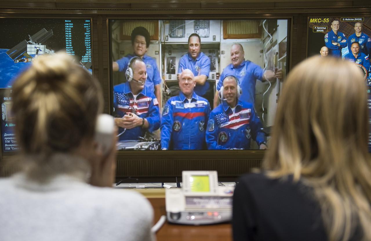 Expedition 55 flight engineers Ricky Arnold of NASA, bottom left, Oleg Artemyev of Roscosmos, bottom center, and Drew Feustel of NASA, bottom right are seen with flight engineer Norishige Kanai of the Japan Aerospace Exploration Agency (JAXA), top left, Commander Anton Shkaplerov of Roscosmos, top center, and flight engineer Scott Tingle of NASA, top right, on a video monitor as they talk to family and friends at the Moscow Mission Control Center in Korolev, Russia a few hours after the Soyuz MS-08 docked to the International Space Station on Saturday, March 24, 2018. Hatches were opened at 5:48 p.m. Eastern time on March 23, 12:48 a.m. Moscow time on March 24. Photo Credit: (NASA/Joel Kowsky)