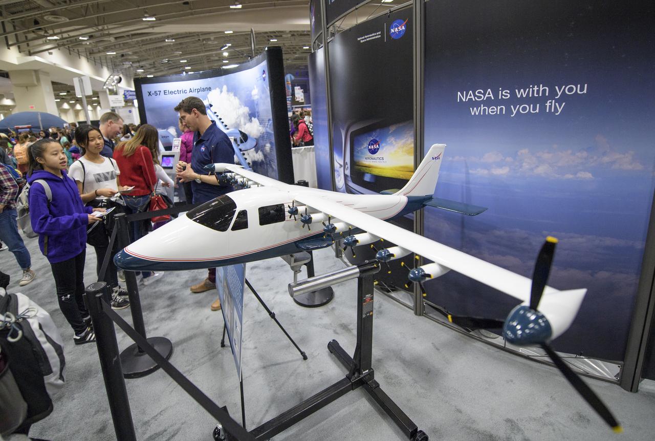 Attendees listen to a NASA staff member speak about the X-57, a research aircraft powered by 14 electric motors, during Sneak Peek Friday at the USA Science and Engineering Festival, Friday, April 6, 2018 at the Walter E. Washington Convention Center in Washington, DC.  The festival is open to the public April 7-8.  Photo Credit: (NASA/Joel Kowsky)