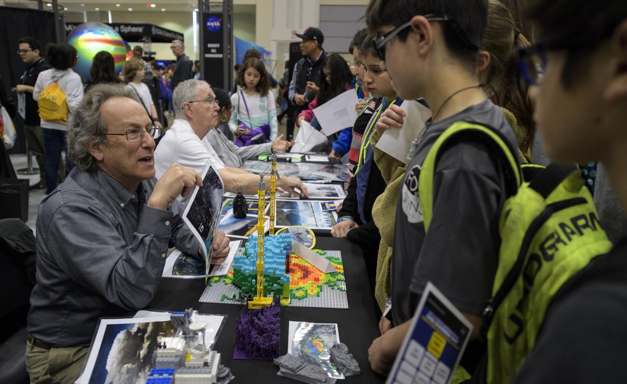 Attendees listen to a NASA staff member talk about the Global Precipitation Measurement mission during Sneak Peek Friday at the USA Science and Engineering Festival, Friday, April 6, 2018 at the Walter E. Washington Convention Center in Washington, DC.  The festival is open to the public April 7-8.  Photo Credit: (NASA/Joel Kowsky)