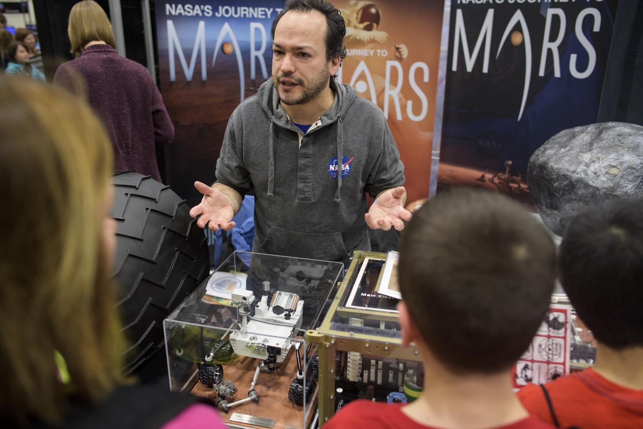 Attendees listen to a NASA staff member talk about NASA's Mars Science Laboratory mission during Sneak Peek Friday at the USA Science and Engineering Festival, Friday, April 6, 2018 at the Walter E. Washington Convention Center in Washington, DC.  The festival is open to the public April 7-8.  Photo Credit: (NASA/Joel Kowsky)