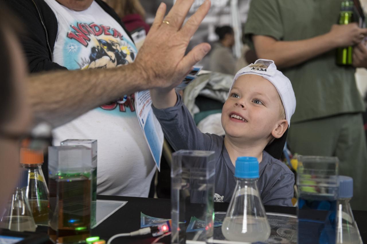 A visitor gives a high five after learning about oceans at one of NASA's exhibits at the Earth Day event on Thursday, April 19, 2018 at Union Station in Washington, D.C. Photo Credit: (NASA/Aubrey Gemignani)