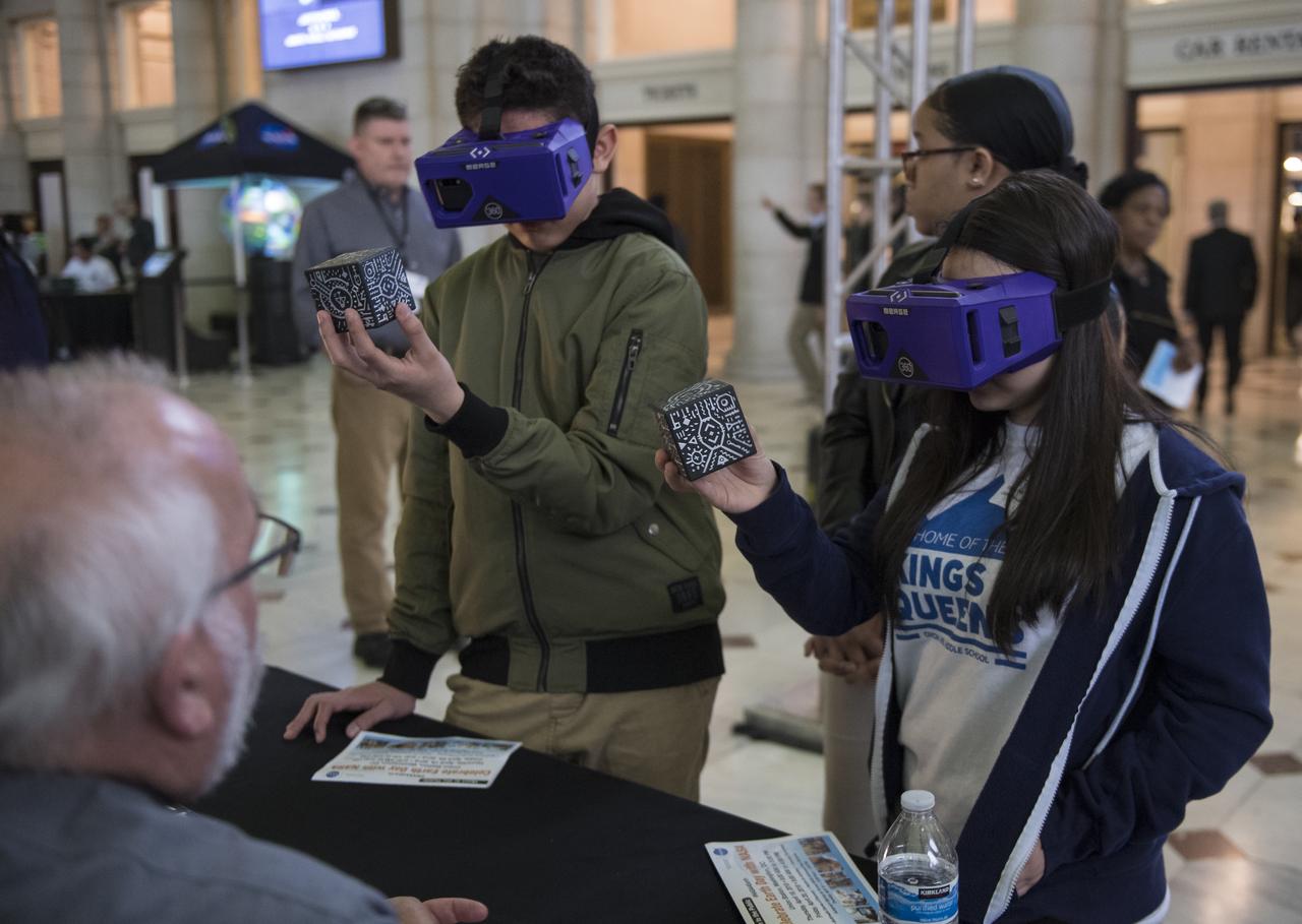 Visitors look through virtual reality goggles at one of NASA's exhibits at the Earth Day event on Thursday, April 19, 2018 at Union Station in Washington, D.C. Photo Credit: (NASA/Aubrey Gemignani)