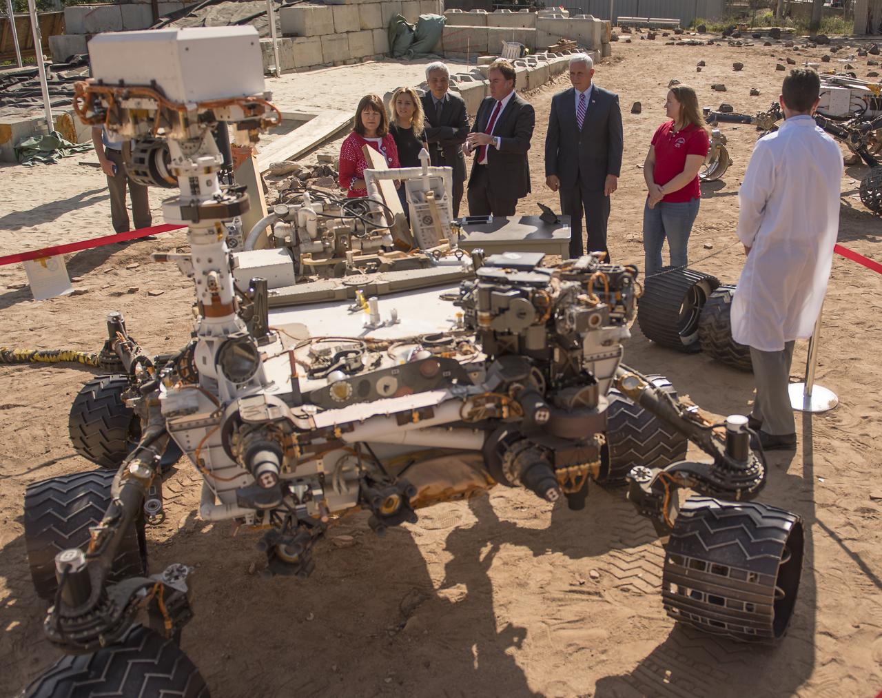U.S. Vice President Mike Pence, 5th from left, joined by his wife Karen Pence, left, and daughter Charlotte Pence. 2nd from left, view the Vehicle System Test Bed (VSTB) rover in the Mars Yard during a tour of NASA's Jet Propulsion Laboratory, Saturday, April 28, 2018 in Pasadena, California. NASA Mars Exploration Manager Li Fuk, 2nd from left, JPL Director Michael Watkins, Mars Curiosity Engineering Operations Team Chief Megan Lin, and MSL Engineer Sean McGill, right, helped explain to the Vice President and his family how they use these test rovers. Photo Credit: (NASA/Bill Ingalls)