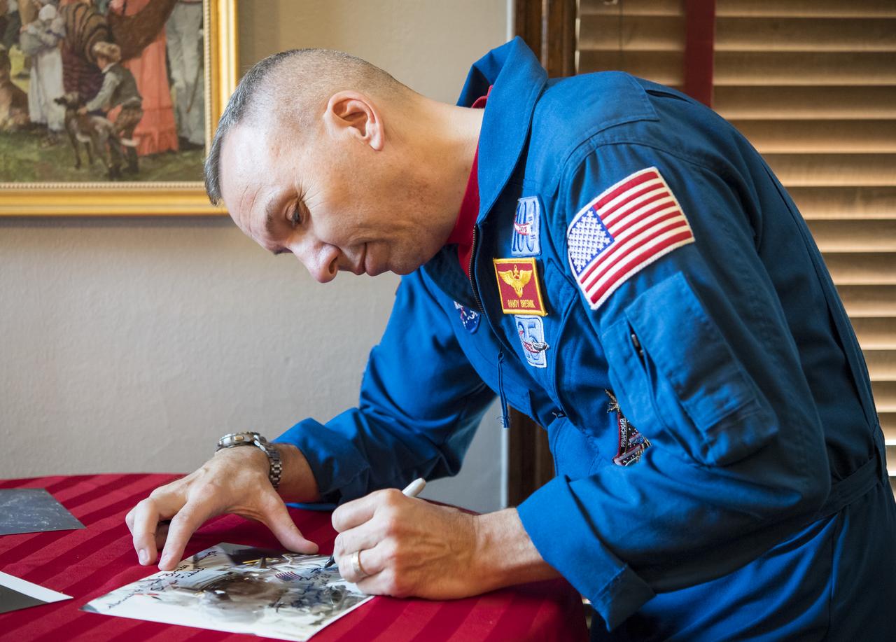 NASA astronaut Randy Bresnik signs photos after speaking to Marines about his time onboard the International Space Station, Monday, May 7, 2018 in Washington. Photo Credit: (NASA/Aubrey Gemignani)