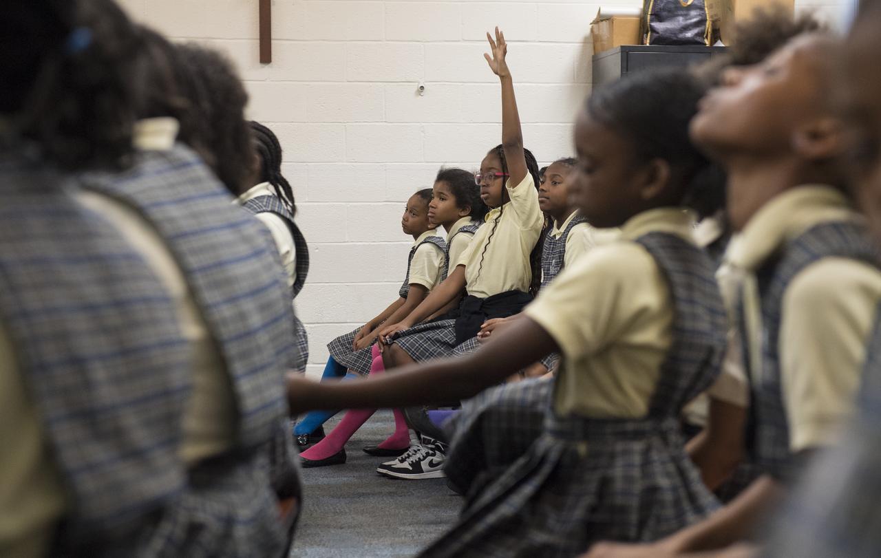 A student raises her hand to ask a question after NASA astronaut Randy Bresnik and ESA astronaut Paolo Nespoli spoke about their time onboard the International Space Station during expeditions 52/53, Friday, May 11, 2018 at the Washington School for Girls in Washington. Photo Credit: (NASA/Aubrey Gemignani)
