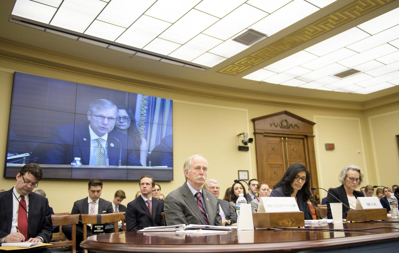 NASA Associate Administrator for the Human Exploration and Operations Mission Directorate William Gerstenmaier, left, Dr. Bhavya Lal, a researcher at the Institute for Defense Analysis's Science and Technology Policy Institute, center, and Dr. Elizabeth Cantwell, chief executive officer at the Arizona State University Research Enterprise, right, listen as Rep. Brian Babin, R-Texas, is seen on screen as he delivers an opening statement during a House Committee on Science, Space, and Technology hearing titled "America's Human Presence in Low-Earth Orbit" on Thursday, May 17, 2018 in the Rayburn House Office Building in Washington. Photo Credit: (NASA/Joel Kowsky)