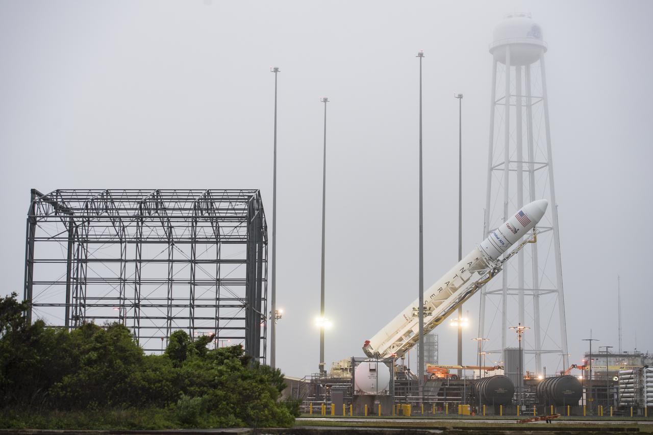 The Orbital ATK Antares rocket, with the Cygnus spacecraft onboard, is raised at launch Pad-0A, Friday, May 18, 2018 at Wallops Flight Facility in Virginia. The Antares will launch with the Cygnus spacecraft filled with 7,400 pounds of cargo for the International Space Station (ISS), including science experiments, crew supplies, and vehicle hardware. The mission is Orbital ATK's ninth contracted cargo delivery flight to ISS for NASA. Photo Credit: (NASA/Aubrey Gemignani)
