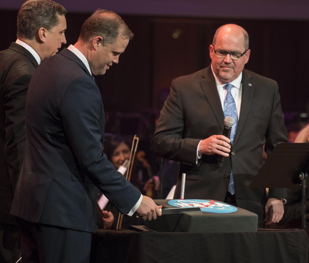 A NASA logo cake is cut by Administrator Bridenstine at the "National Symphony Orchestra Pops: Space, the Next Frontier" event celebrating NASA's 60th Anniversary, Friday, June 1, 2018 at the John F. Kennedy Center for the Performing Arts in Washington. The event featured music inspired by space including artists will.i.am, Grace Potter, Coheed & Cambria, John Cho, and guest Nick Sagan, son of Carl Sagan. Photo Credit: (NASA/Aubrey Gemignani)