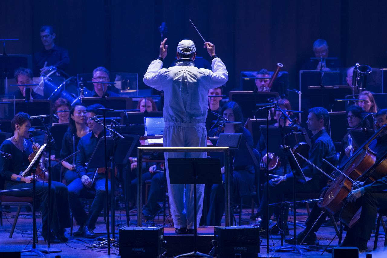 Conductor Emil de Cou leads the National Symphony Orchestra during the "Space, the Next Frontier" event celebrating NASA's 60th Anniversary, Friday, June 1, 2018 at the John F. Kennedy Center for the Performing Arts in Washington. The event featured music inspired by space including artists will.i.am, Grace Potter, Coheed & Cambria, John Cho, and guest Nick Sagan, son of Carl Sagan. Photo Credit: (NASA/Aubrey Gemignani)