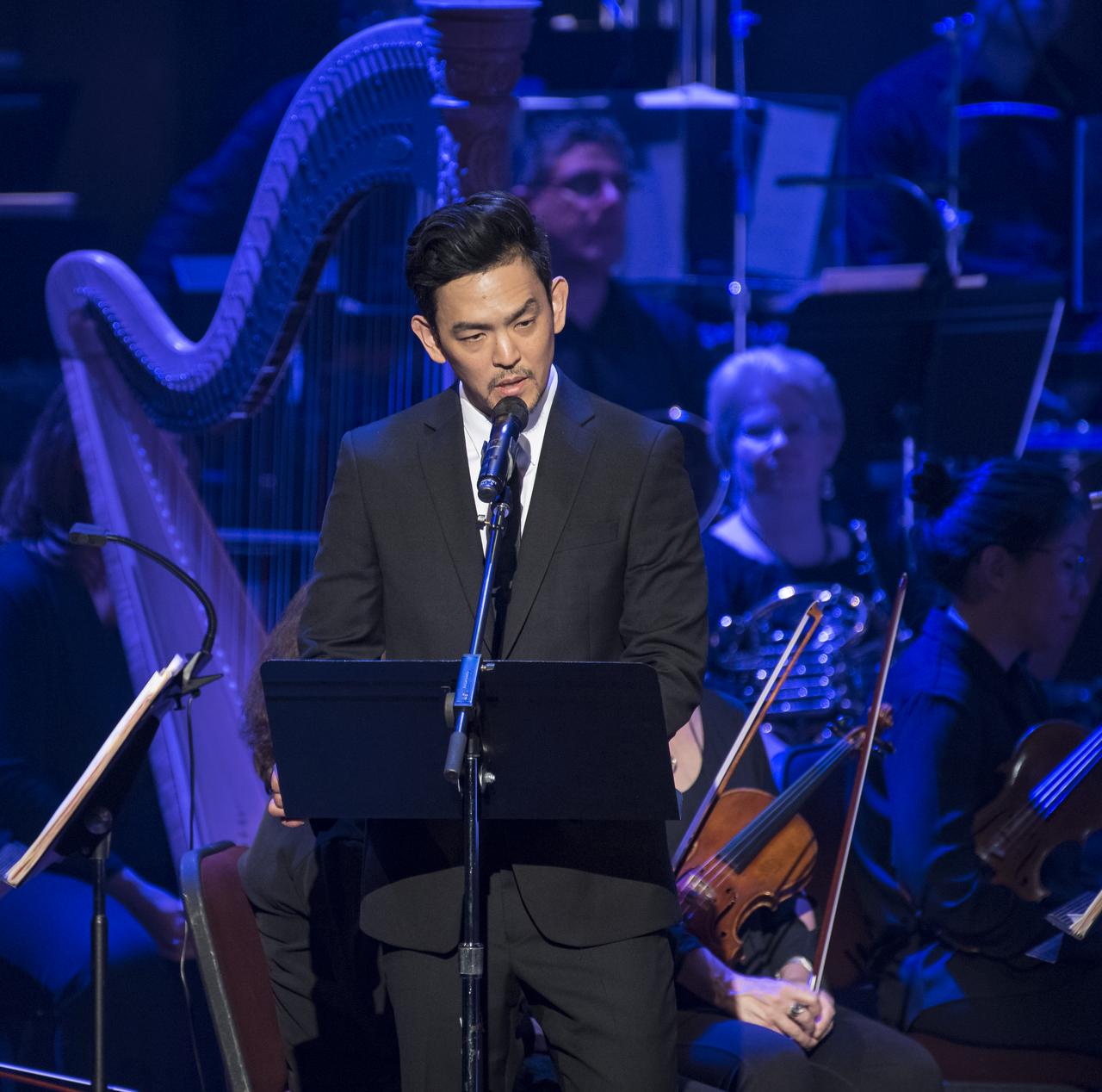 Actor John Cho recites a poem during the "National Symphony Orchestra Pops: Space, the Next Frontier" event celebrating NASA's 60th Anniversary, Friday, June 1, 2018 at the John F. Kennedy Center for the Performing Arts in Washington. The event featured music inspired by space including artists will.i.am, Grace Potter, Coheed & Cambria, John Cho, and guest Nick Sagan, son of Carl Sagan. Photo Credit: (NASA/Aubrey Gemignani)