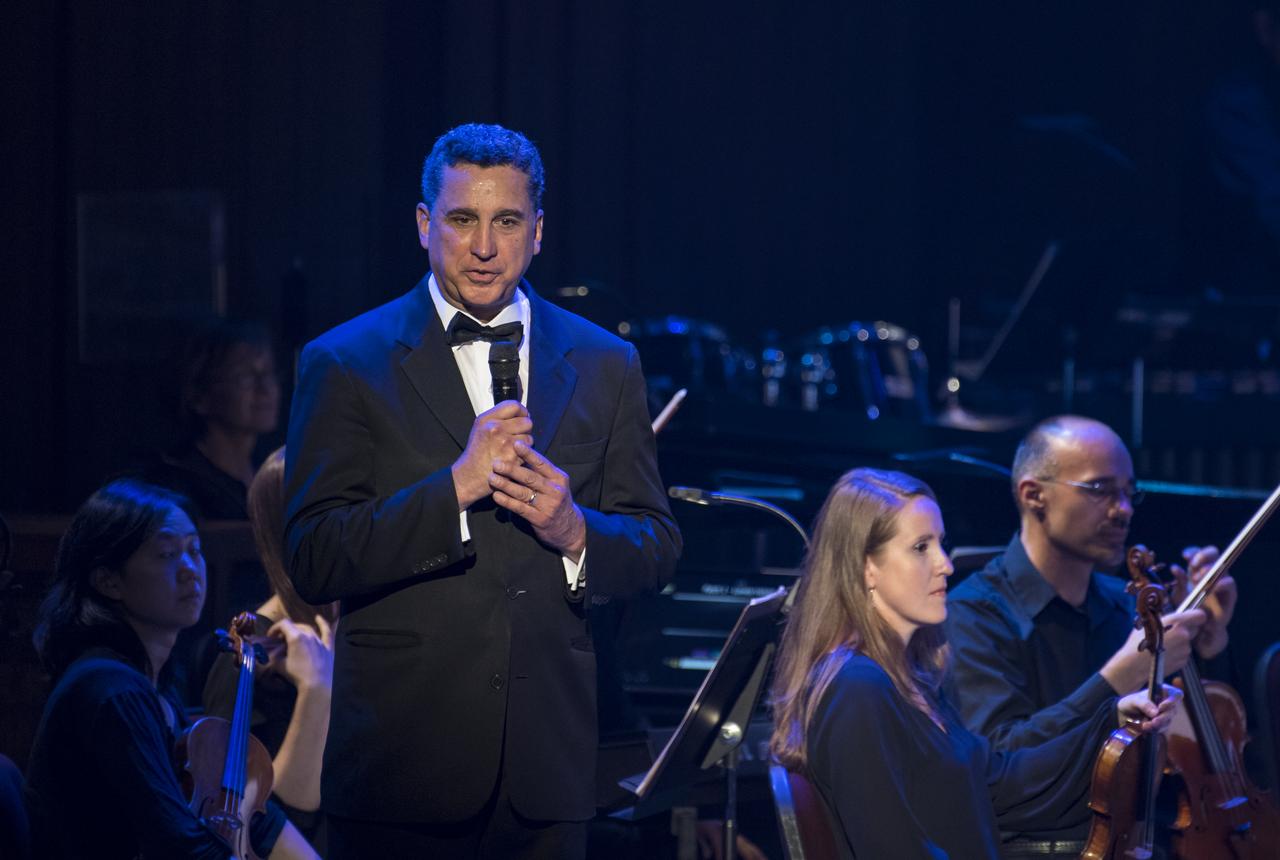 Conductor Emil de Cou speaks after leading the National Symphony Orchestra during the "Space, the Next Frontier" event celebrating NASA's 60th Anniversary, Friday, June 1, 2018 at the John F. Kennedy Center for the Performing Arts in Washington. The event featured music inspired by space including artists will.i.am, Grace Potter, Coheed & Cambria, John Cho, and guest Nick Sagan, son of Carl Sagan. Photo Credit: (NASA/Aubrey Gemignani)