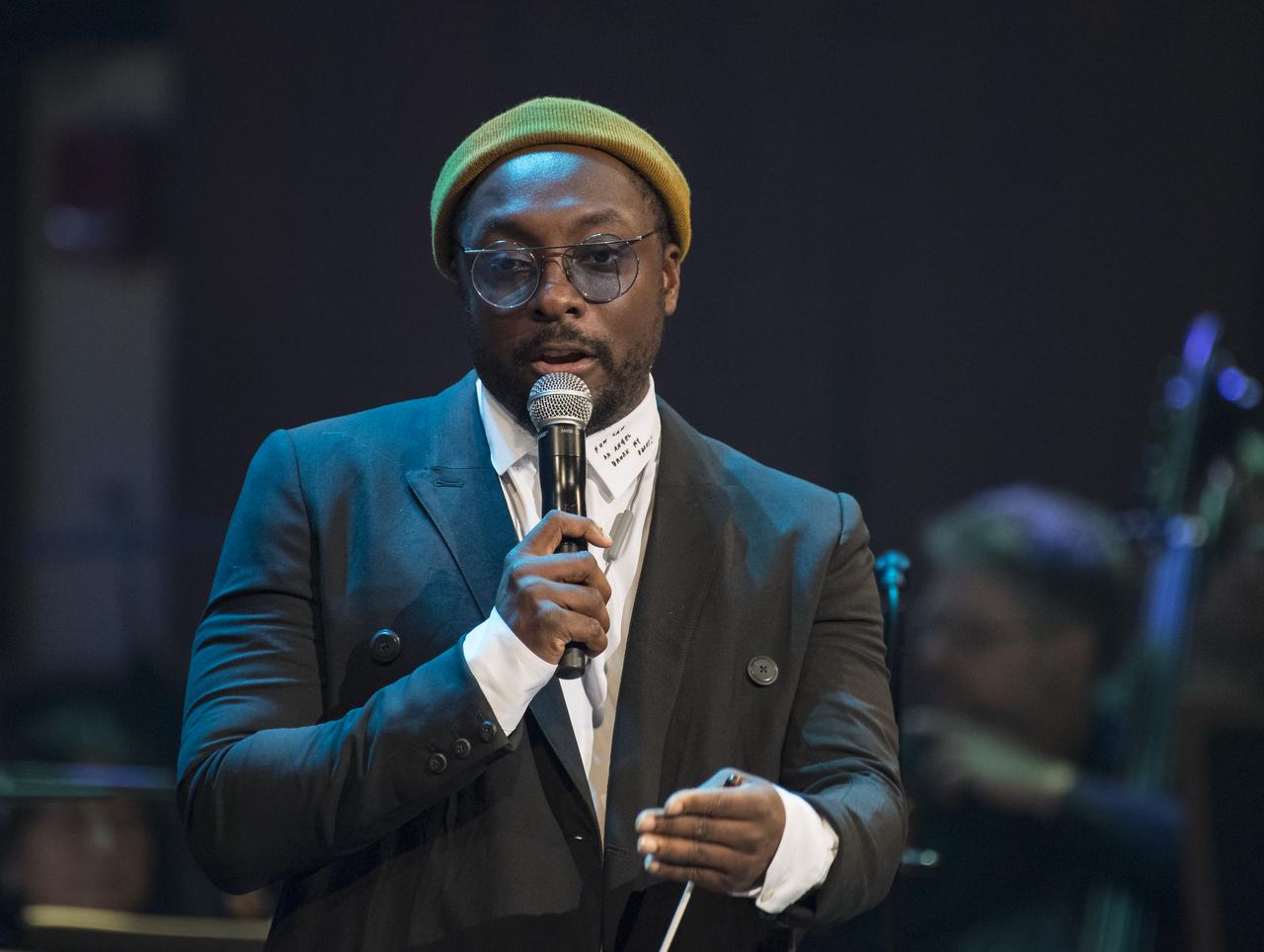 Will.i.am speaks before conducting the National Symphony Orchestra during the "Space, the Next Frontier" event celebrating NASA's 60th Anniversary, Friday, June 1, 2018 at the John F. Kennedy Center for the Performing Arts in Washington. The event featured music inspired by space including artists will.i.am, Grace Potter, Coheed & Cambria, John Cho, and guest Nick Sagan, son of Carl Sagan. Photo Credit: (NASA/Aubrey Gemignani)