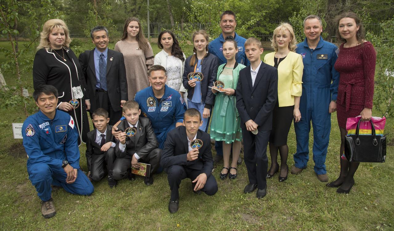 Japan Aerospace Exploration Agency astronauts, Takuya Onishi, lower left, Koichi Wakata, 2nd from left standing, along with NASA astronauts Doug Wheelock, kneeling center, and Kjell Lindgren, standing center, meet with children from a local orphanage at the Cosmonaut Hotel, Saturday, June 2, 2018 in Karaganda, Kazakhstan. The astronauts were in Karaganda to help support the Expedition 55 crew Soyuz landing from the International Space Station. Photo Credit: (NASA/Bill Ingalls)