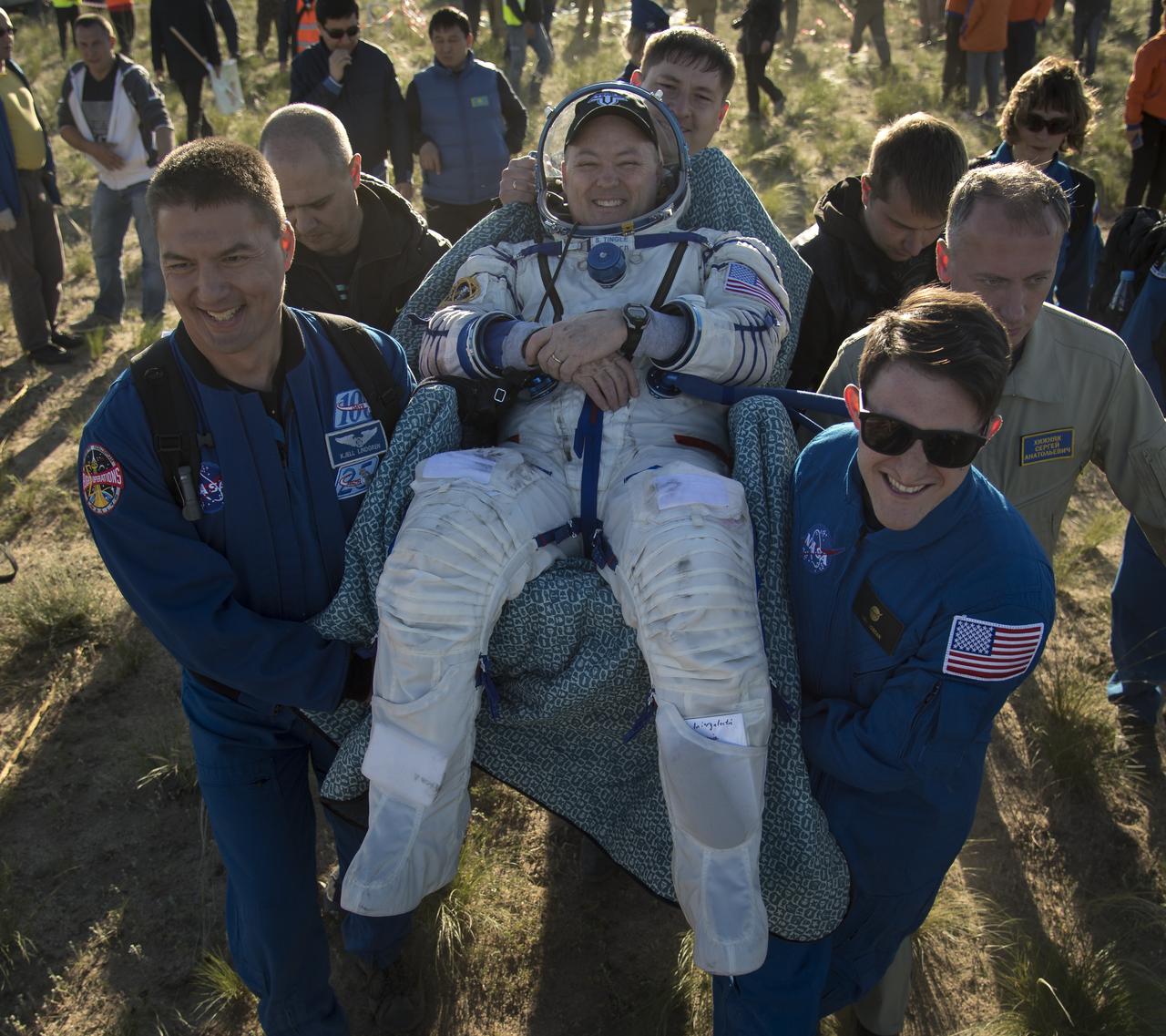NASA astronaut Scott Tingle is carried to a medical tent by NASA astronaut and Astronaut Office Representative Kjell Lindgren, left, and NASA Public Affairs Officer Gary Jordan, right, shortly after he, Japan Aerospace Exploration Agency (JAXA) astronaut Norishige Kanai, and Roscosmos cosmonaut Anton Shkaplerov landed in their Soyuz MS-07 spacecraft near the town of Zhezkazgan, Kazakhstan on Sunday, June 3, 2018. Shkaplerov, Tingle, and Kanai are returning after 168 days in space where they served as members of the Expedition 54 and 55 crews onboard the International Space Station. Photo Credit: (NASA/Bill Ingalls)