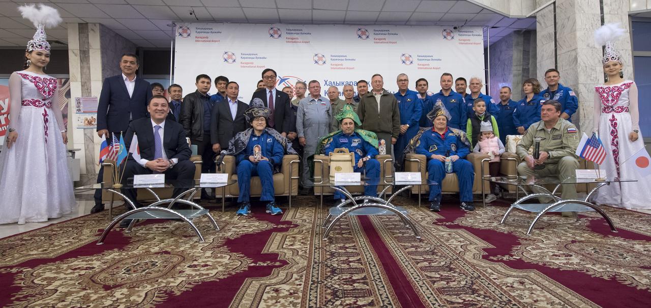 Japan Aerospace Exploration Agency (JAXA) astronaut Norishige Kanai, left, Roscosmos cosmonaut Anton Shkaplerov, center, and NASA astronaut Scott Tingle are seen in a group photo with other others at a Karaganda Airport welcome ceremony in Kazakhstan on Sunday, June 3, 2018. Kandi, Shkaplerov, and Tingle are returning after 168 days in space where they served as members of the Expedition 54 and 55 crews onboard the International Space Station. Photo Credit: (NASA/Bill Ingalls)