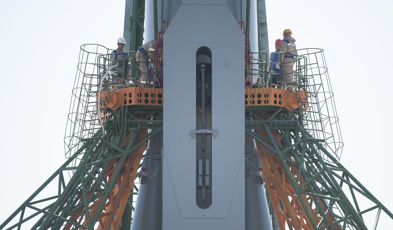 Workers are seen on a gantry after the Soyuz rocket was raised into a vertical position on the launch pad, Monday, June 4, 2018 at the Baikonur Cosmodrome in Kazakhstan. Expedition 56 Soyuz Commander Sergey Prokopyev of Roscosmos, flight engineer Serena Auñón-Chancellor of NASA, and flight engineer Alexander Gerst of ESA (European Space Agency) are scheduled to launch aboard their Soyuz MS-09 spacecraft at 7:12 a.m. Eastern time (5:12 p.m. Baikonur time), on Wednesday, June 6. Photo Credit: (NASA/Joel Kowsky)