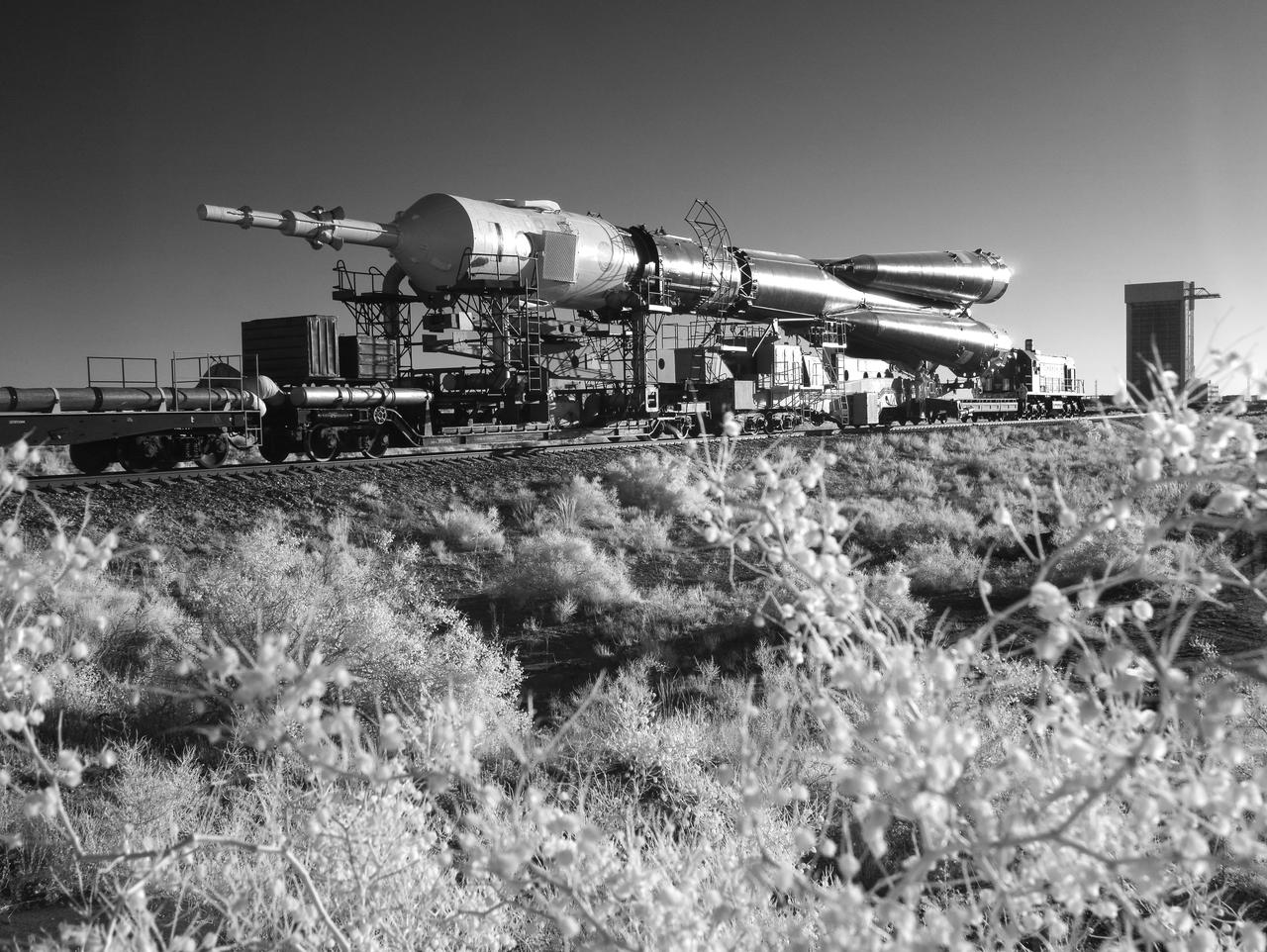 In this black and white infrared image, the Soyuz rocket is seen as it is rolled out by train to the launch pad, Monday, June 4, 2018 at the Baikonur Cosmodrome in Kazakhstan. Expedition 56 Soyuz Commander Sergey Prokopyev of Roscosmos, flight engineer Serena Auñón-Chancellor of NASA, and flight engineer Alexander Gerst of ESA (European Space Agency) are scheduled to launch aboard their Soyuz MS-09 spacecraft at 7:12 a.m. Eastern time (5:12 p.m. Baikonur time), on Wednesday, June 6. Photo Credit: (NASA/Joel Kowsky)