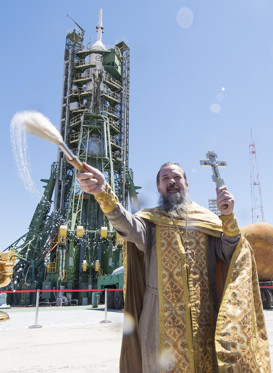 An Orthodox Priest blesses members of the media at the Baikonur Cosmodrome launch pad, Tuesday, June 5, 2018 in Baikonur, Kazakhstan. Expedition 56 Soyuz Commander Sergey Prokopyev of Roscosmos, flight engineer Serena Auñón-Chancellor of NASA, and flight engineer Alexander Gerst of ESA (European Space Agency) are scheduled to launch to the International Space Station aboard the Soyuz MS-09 spacecraft on Wednesday, June 6. Photo Credit: (NASA/Joel Kowsky)