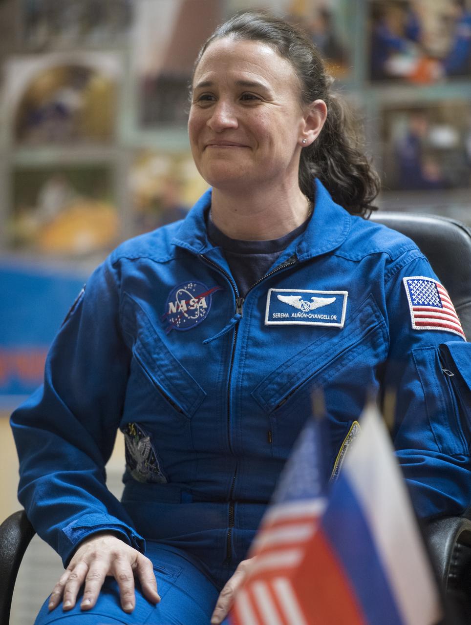 Expedition 56 flight engineer Serena Auñón-Chancellor of NASA is seen in quarantine, behind glass, during a press conference, Tuesday, June 5, 2018 a the Cosmonaut Hotel in Baikonur, Kazakhstan. Auñón-Chancellor, Soyuz Commander Sergey Prokopyev of Roscosmos, and flight engineer Alexander Gerst of ESA (European Space Agency) are scheduled to launch to the International Space Station aboard the Soyuz MS-09 spacecraft on Wednesday, June 6. Photo Credit: (NASA/Joel Kowsky)