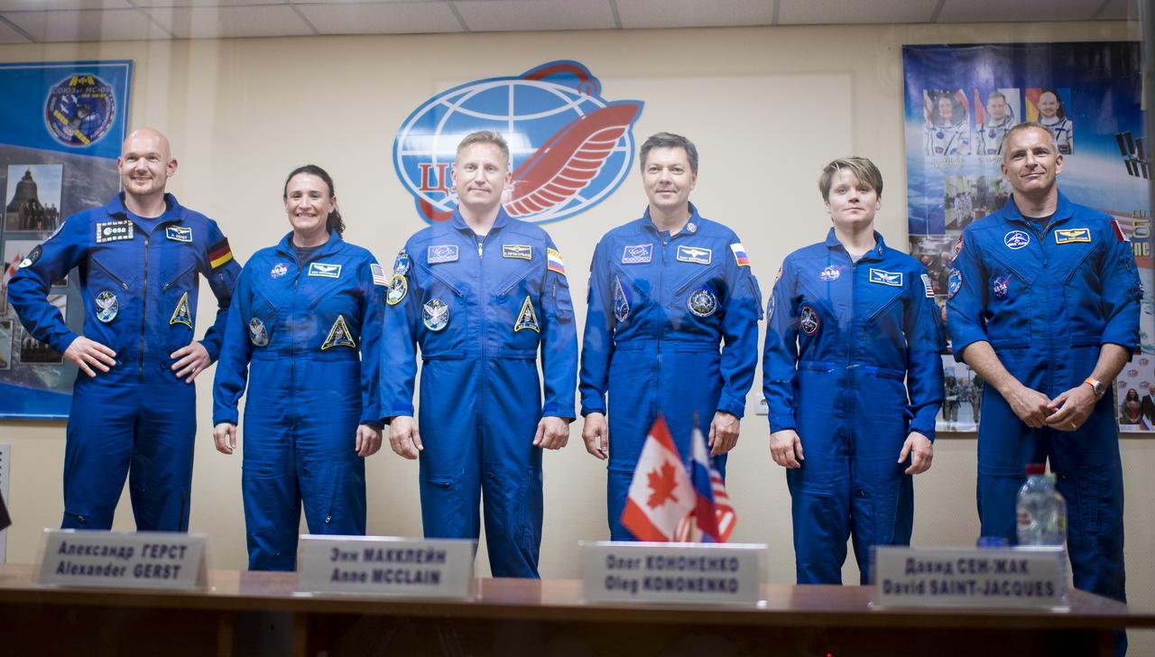 Expedition 56 prime crew members Alexander Gerst of ESA (European Space Agency), left, Serena Auñón-Chancellor of NASA, second from left, and Sergey Prokopyev of Roscosmos, third from left, pose for a picture with backup crew members Oleg Artemyev of Roscosmos, third from right, Anne McClain of NASA, second from right, and David Saint-Jacques of the Canadian Space Agency, right, pose for a picture following the conclusion of a press conference, Tuesday, June 5, 2018 a the Cosmonaut Hotel in Baikonur, Kazakhstan. Expedition 56 Soyuz Commander Sergey Prokopyev of Roscosmos, flight engineer Serena Auñón-Chancellor of NASA, and flight engineer Alexander Gerst of ESA (European Space Agency) are scheduled to launch to the International Space Station aboard the Soyuz MS-09 spacecraft on Wednesday, June 6.  Photo Credit: (NASA/Joel Kowsky)