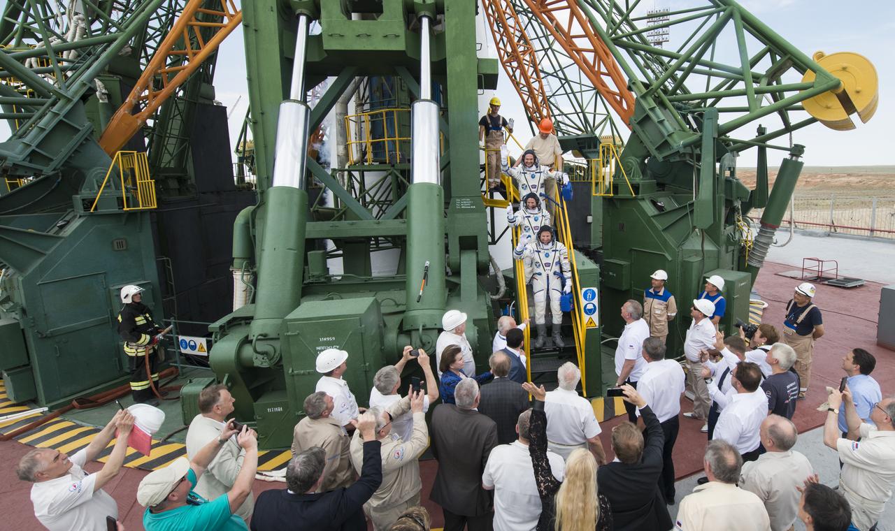 Expedition 56 flight engineer Alexander Gerst of ESA (European Space Agency), top, flight engineer Serena Auñón-Chancellor of NASA, middle, and Soyuz Commander Sergey Prokopyev of Roscosmos, bottom, wave farewell prior to boarding the Soyuz MS-09 spacecraft for launch, Wednesday, June 6, 2018 at the Baikonur Cosmodrome in Kazakhstan. Gerst, Auñón-Chancellor, and Prokopyev will spend the next six months living and working aboard the International Space Station. Photo Credit: (NASA/Joel Kowsky)