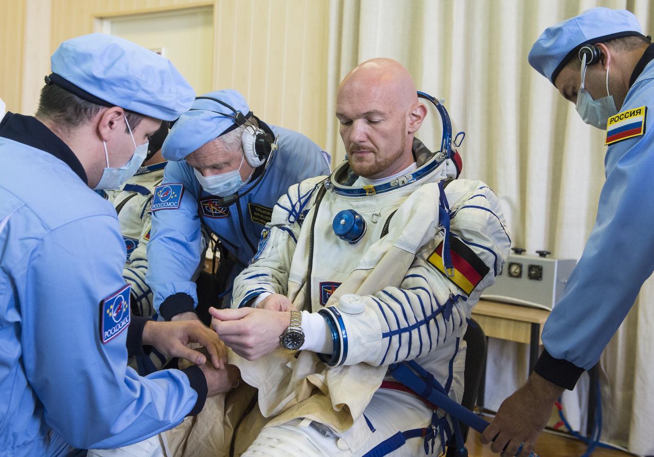 Expedition 56 flight engineer Alexander Gerst of ESA (European Space Agency) is helped into his Russian Sokol suit as he and fellow crewmates, Sergey Prokopyev of Roscosmos and Serena Auñón-Chancellor of NASA prepare for their Soyuz launch to the International Space Station Wednesday, June 6, 2018 at the Baikonur Cosmodrome in Kazakhstan.  Launch of the Soyuz rocket will send Gerst, Auñón-Chancellor, and Prokopyev on a six month mission aboard the International Space Station. Photo Credit: (NASA/GCTC/Andrey Shelepin)