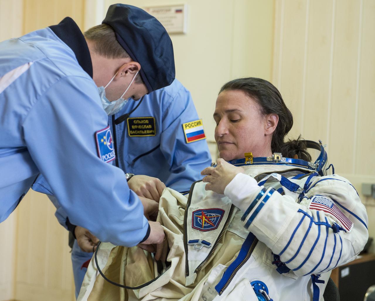 Expedition 56 flight engineer Serena Auñón-Chancellor of NASA is helped into her Russian Sokol suit as she and fellow crewmates, Sergey Prokopyev of Roscosmos and Alexander Gerst of ESA (European Space Agency) prepare for their Soyuz launch to the International Space Station Wednesday, June 6, 2018 at the Baikonur Cosmodrome in Kazakhstan. Launch of the Soyuz rocket will send Auñón-Chancellor, Prokopyev, and Gerst on a six month mission aboard the International Space Station. Photo Credit: (NASA/GCTC/Andrey Shelepin)