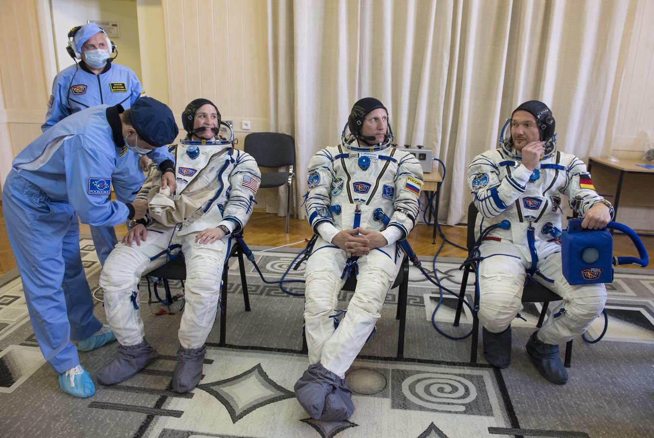 Expedition 56 flight engineer Serena Auñón-Chancellor of NASA, left, Soyuz Commander Sergey Prokopyev of Roscosmos, center, and flight engineer Alexander Gerst of ESA (European Space Agency) are seen after donning their Russian Sokol suits as they prepare for their Soyuz launch to the International Space Station, Wednesday, June 6, 2018 at the Baikonur Cosmodrome in Kazakhstan.  Launch of the Soyuz rocket will send Auñón-Chancellor, Prokopyev, and Gerst on a six month mission aboard the International Space Station. Photo Credit: (NASA/GCTC/Andrey Shelepin)