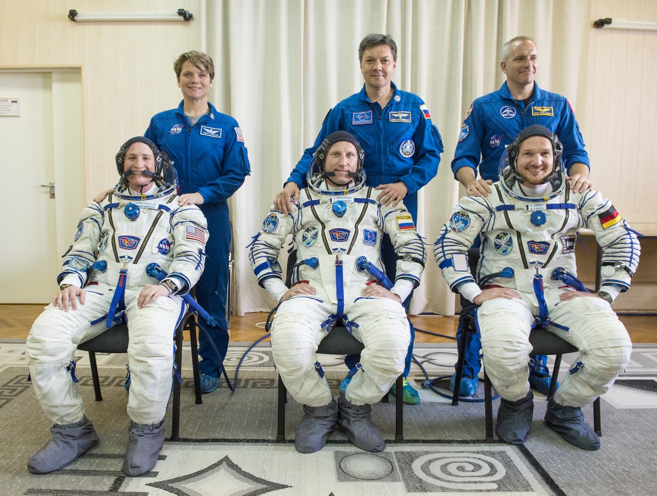 Expedition 56 backup crew members Anne McClain of NASA, back left, Oleg Kononenko of Roscosmos, back center, and David Saint-Jacques of the Canadian Space Agency, back right, stand behind prime crew members flight engineer Serena Auñón-Chancellor of NASA, from left, Soyuz Commander Sergey Prokopyev of Roscosmos, front center, and flight engineer Alexander Gerst of ESA (European Space Agency), front right, after donning their Russian Sokol suits as they prepare for their Soyuz launch to the International Space Station Wednesday, June 6, 2018 at the Baikonur Cosmodrome in Kazakhstan.  Launch of the Soyuz rocket will send Auñón-Chancellor, Prokopyev, and Gerst on a six month mission aboard the International Space Station. Photo Credit: (NASA/GCTC/Andrey Shelepin)