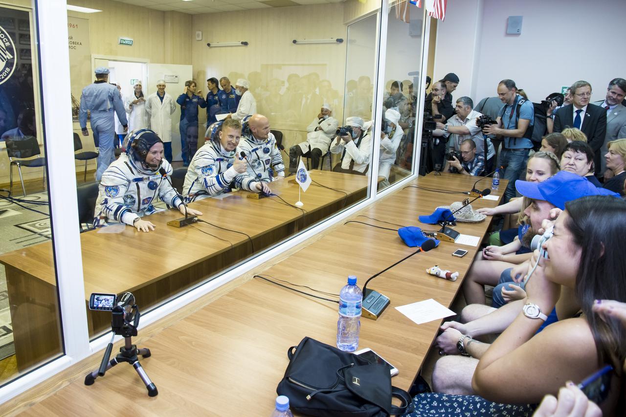 Expedition 56 flight engineer Serena Auñón-Chancellor of NASA, left, Soyuz Commander Sergey Prokopyev of Roscosmos, center, and flight engineer Alexander Gerst or ESA (European Space Agency), right, are seen as they talk with family and friends after having their Russian Sokol suits pressure checked in preparation for launch aboard the Soyuz MS-09 spacecraft, Wednesday, June 6, 2018 at the Baikonur Cosmodrome in Kazakhstan. Auñón-Chancellor, Prokopyev, and Gerst launched aboard the Soyuz MS-09 spacecraft at 7:12am EDT (5:12pm Baikonur time) on June 6 to begin their journey to the International Space Station.  Photo Credit: (NASA/Victor Zelentsov)