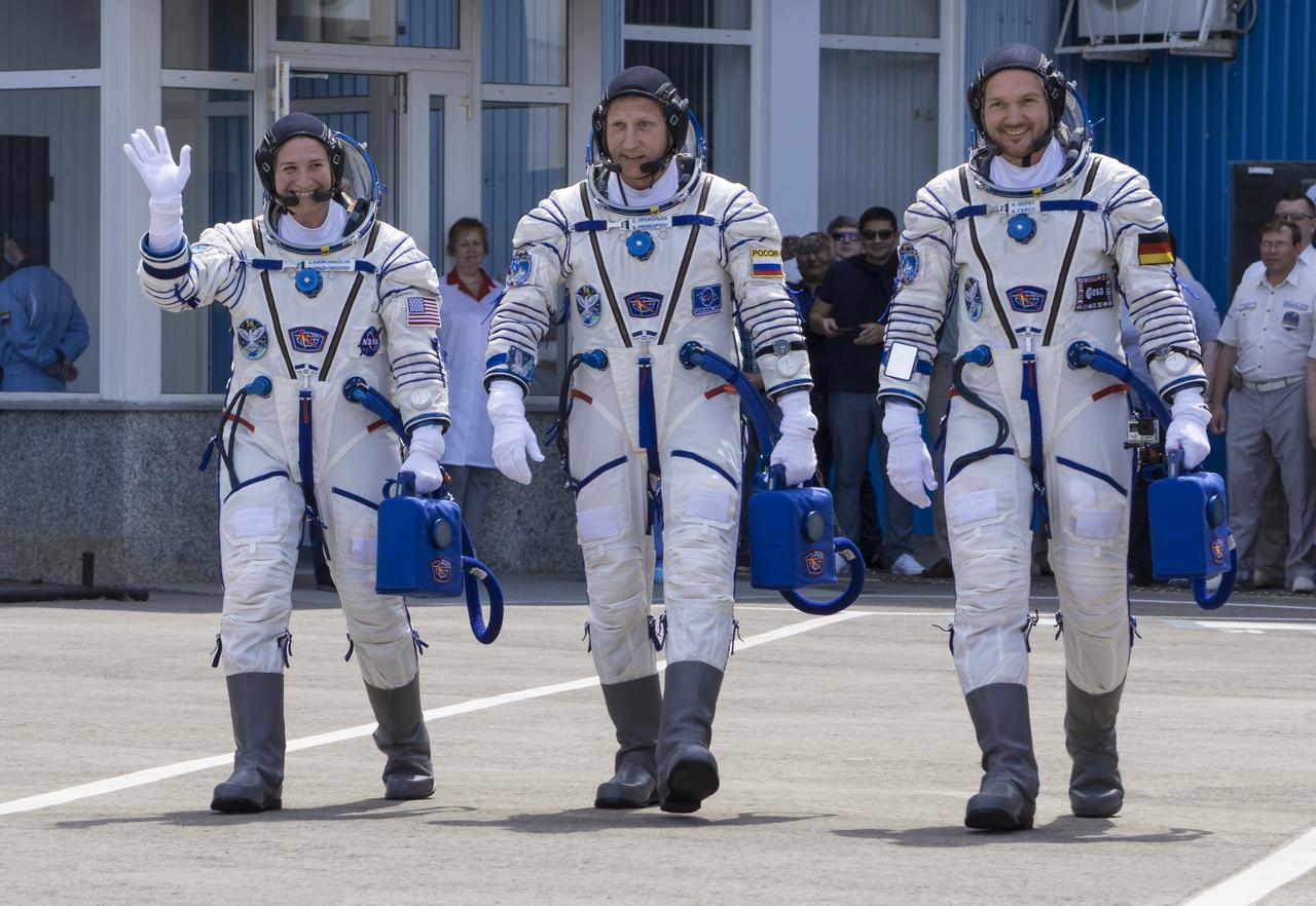 Expedition 56 flight engineer Serena Auñón-Chancellor of NASA, left, Soyuz Commander Sergey Prokopyev of Roscosmos, center, and flight engineer Alexander Gerst of ESA (European Space Agency), right, are seen as they depart Building 254 and report to mission managers a few hours before their launch, Wednesday, June 6, 2018 at the Baikonur Cosmodrome in Kazakhstan. Auñón-Chancellor, Prokopyev, and Gerst launched aboard the Soyuz MS-09 spacecraft at 7:12am EDT (5:12pm Baikonur time) on June 6 to begin their journey to the International Space Station. Photo Credit: (NASA/Victor Zelentsov)