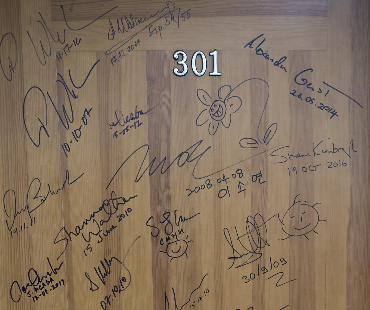 Signatures of astronauts, and cosmonauts from various countries can be seen on a door of a room in the Cosmonaut Hotel, Wednesday, June 6, 2018 in Baikonur, Kazakhstan. Expedition 56 crewmembers Serena Auñón-Chancellor of NASA, Sergey Prokopyev of Roscosmos, and Alexander Gerst of ESA (European Space Agency) will follow the traditional and sign the door ahead of their launch onboard a Soyuz MS-09 spacecraft. Auñón-Chancellor, Prokopyev, and Gerst launched aboard the Soyuz MS-09 spacecraft at 7:12am EDT (5:12pm Baikonur time) on June 6 to begin their journey to the International Space Station. Photo Credit: (NASA/Joel Kowsky)