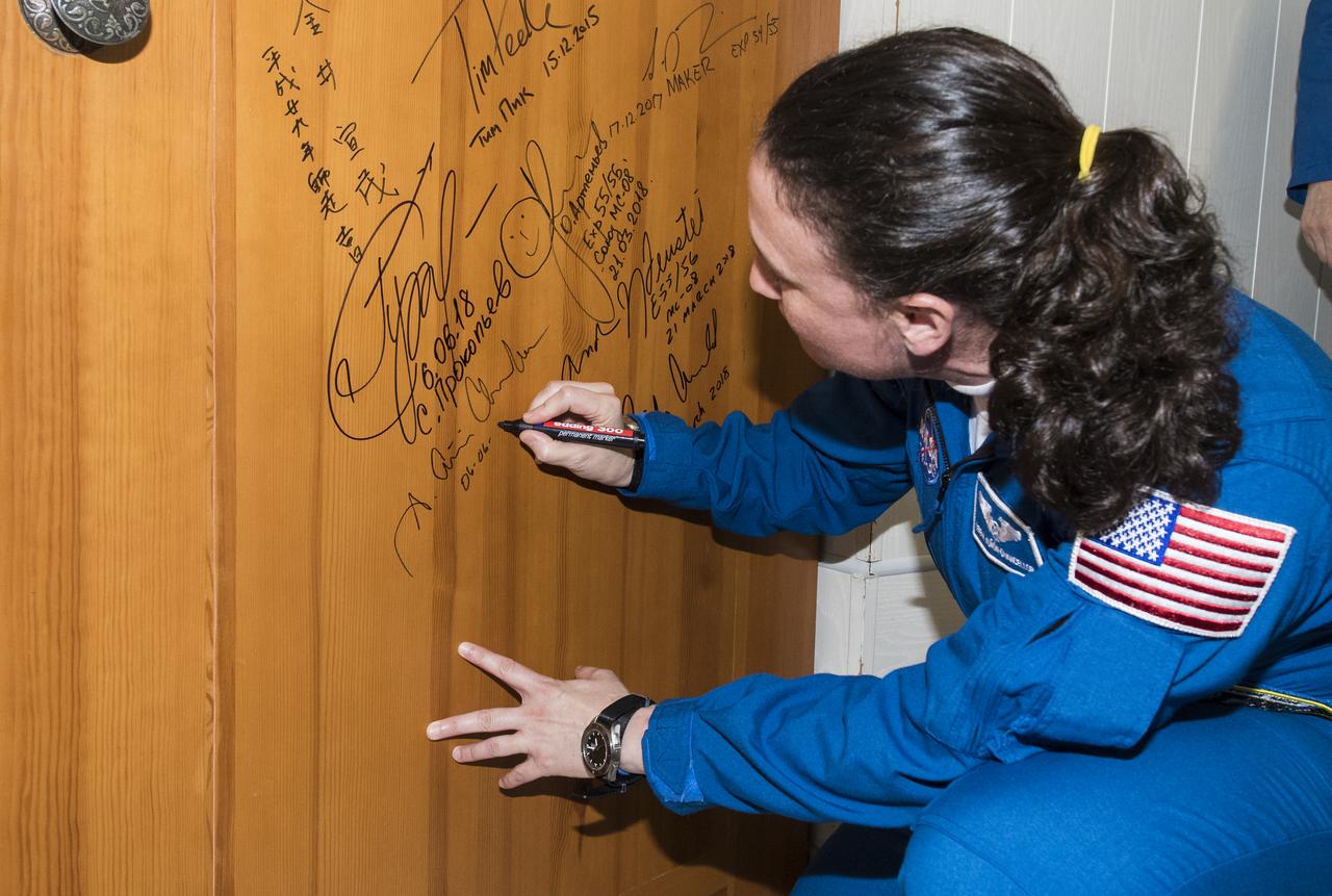 Expedition 56 flight engineer Serena Auñón-Chancellor of NASA performs the traditional door signing at the Cosmonaut Hotel prior to departing the hotel for launch on a Soyuz rocket with fellow crewmates Sergey Prokopyev of Roscosmos and Alexander Gerst of ESA (European Space Agency), Wednesday, June 6, 2018 in Baikonur, Kazakhstan. Auñón-Chancellor, Prokopyev, and Gerst will launch in their Soyuz MS-09 spacecraft to the International Space Station to being a six month mission. Photo Credit: (NASA/Joel Kowsky)