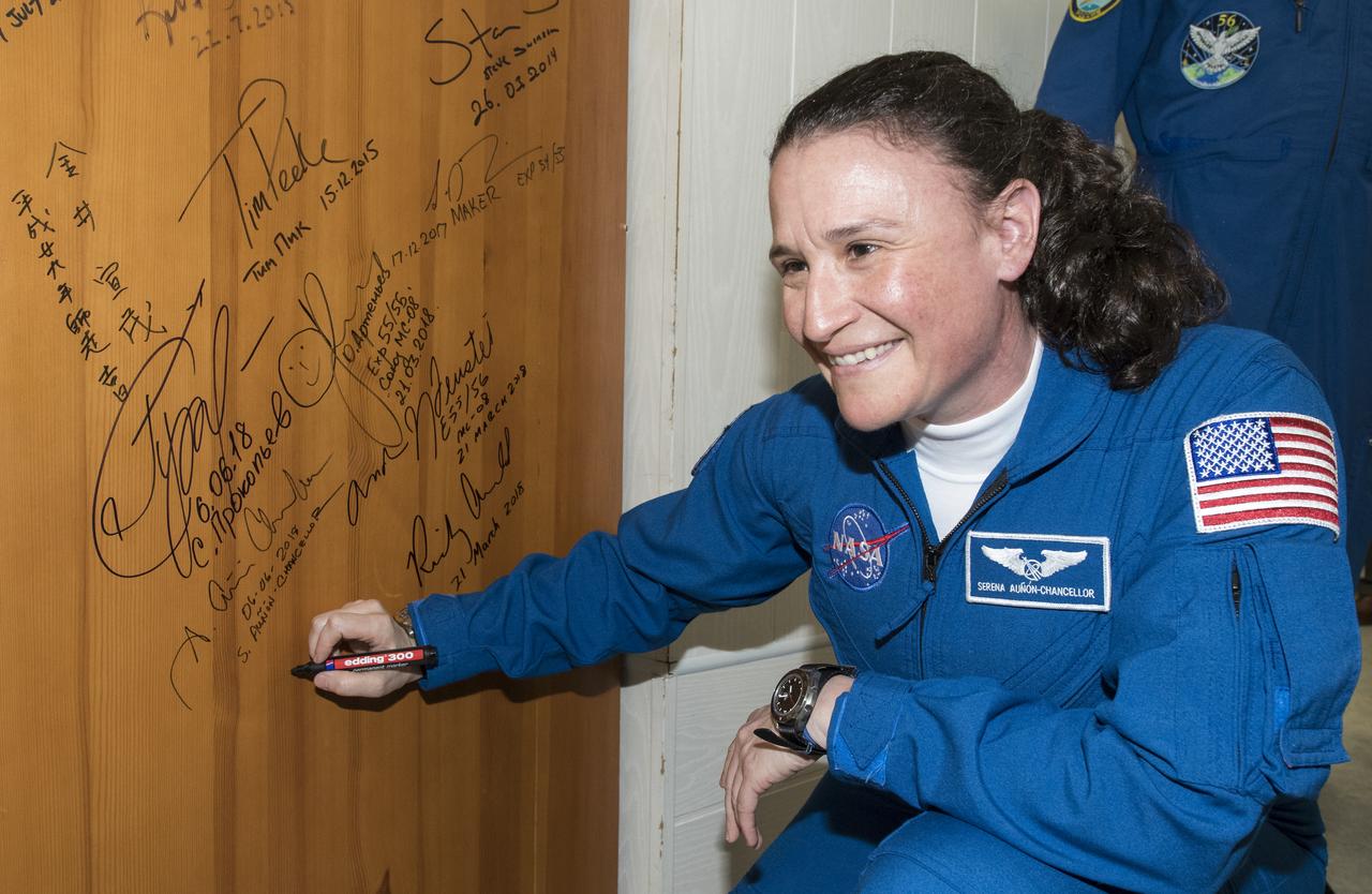 Expedition 56 flight engineer Serena Auñón-Chancellor of NASA performs the traditional door signing at the Cosmonaut Hotel prior to departing the hotel for launch on a Soyuz rocket with fellow crewmates Sergey Prokopyev of Roscosmos and Alexander Gerst of ESA (European Space Agency), Wednesday, June 6, 2018 in Baikonur, Kazakhstan. Auñón-Chancellor, Prokopyev, and Gerst will launch in their Soyuz MS-09 spacecraft to the International Space Station to being a six month mission. Photo Credit: (NASA/Joel Kowsky)