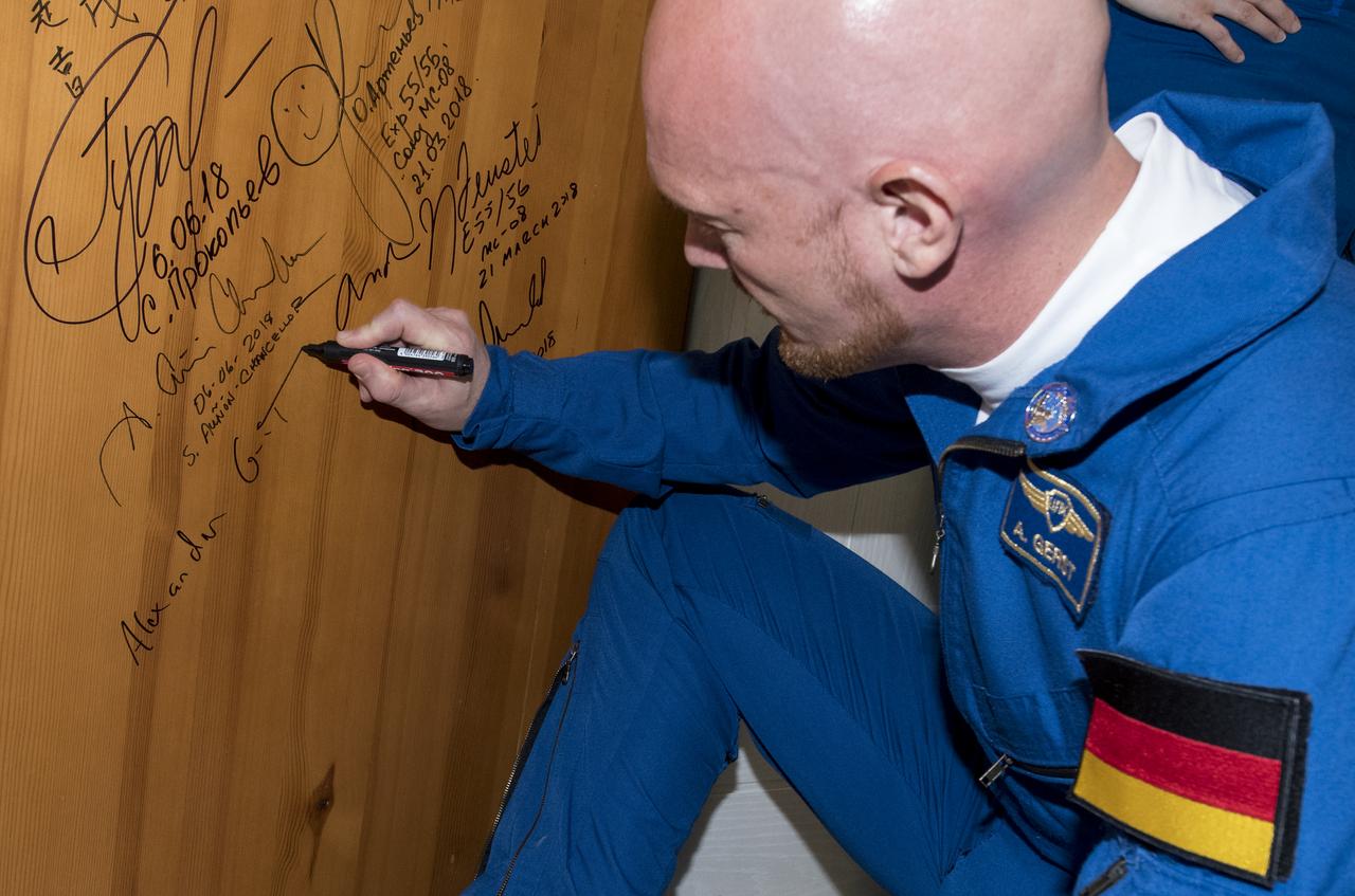 Expedition 56 flight engineer Alexander Gerst of ESA (European Space Agency) performs the traditional door signing at the Cosmonaut Hotel prior to departing the hotel for launch on a Soyuz rocket with fellow crewmates Serena Auñón-Chancellor of NASA and Sergey Prokopyev of Roscosmos, Wednesday, June 6, 2018 in Baikonur, Kazakhstan. Gerst, Auñón-Chancellor, and Prokopyev will launch in their Soyuz MS-09 spacecraft to the International Space Station to being a six month mission.  Photo Credit: (NASA/Joel Kowsky)