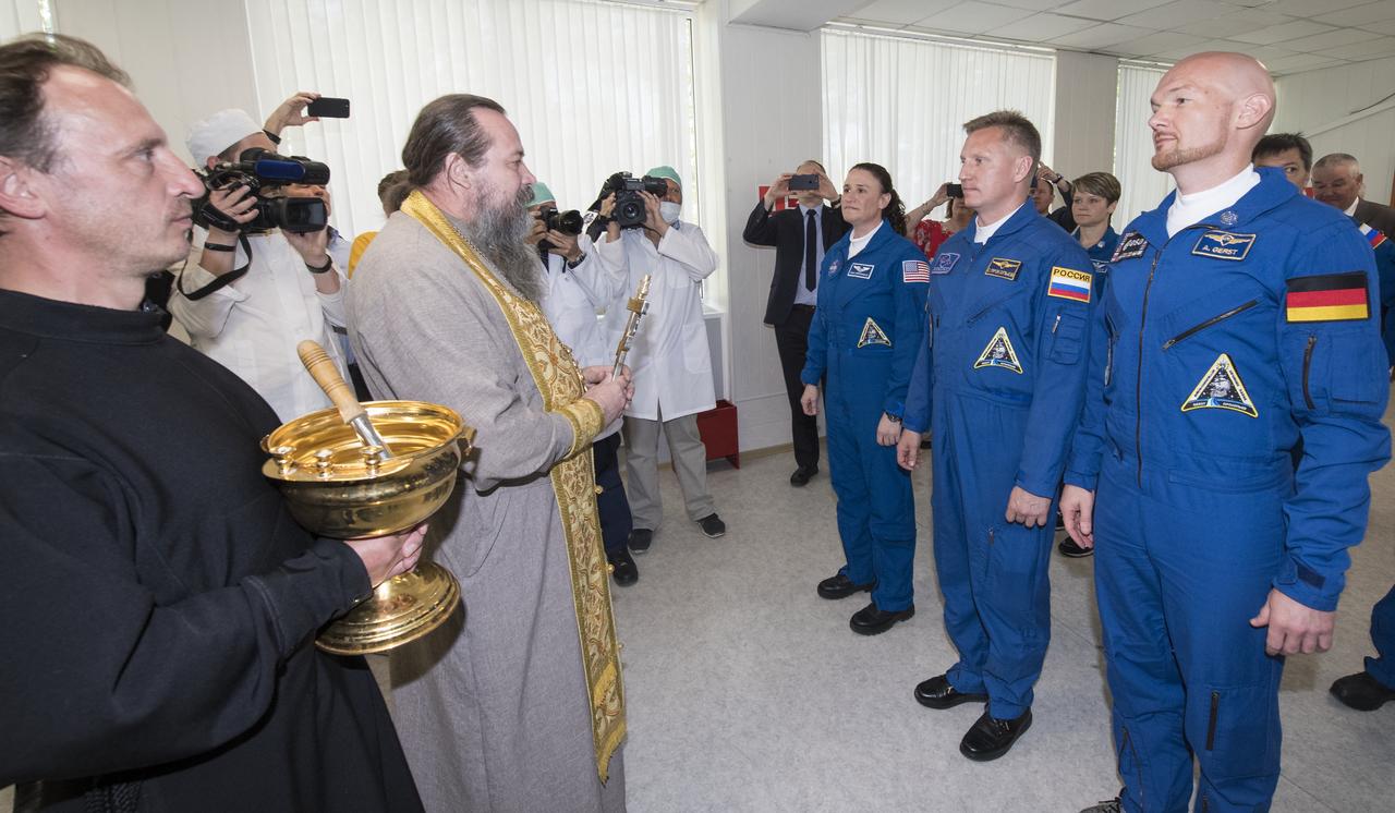 Expedition 56 flight engineer Serena Auñón-Chancellor of NASA, Soyuz Commander Sergey Prokopyev of Roscosmos, and flight engineer Alexander Gerst of ESA (European Space Agency) receive a blessing from a Russian Orthodox Priest at the Cosmonaut Hotel prior to departing the hotel for launch on a Soyuz rocket, Wednesday, June 6, 2018 in Baikonur, Kazakhstan.  Auñón-Chancellor, Prokopyev, and Gerst will launch in their Soyuz MS-09 spacecraft to the International Space Station to being a six month mission.  Photo Credit: (NASA/Joel Kowsky)