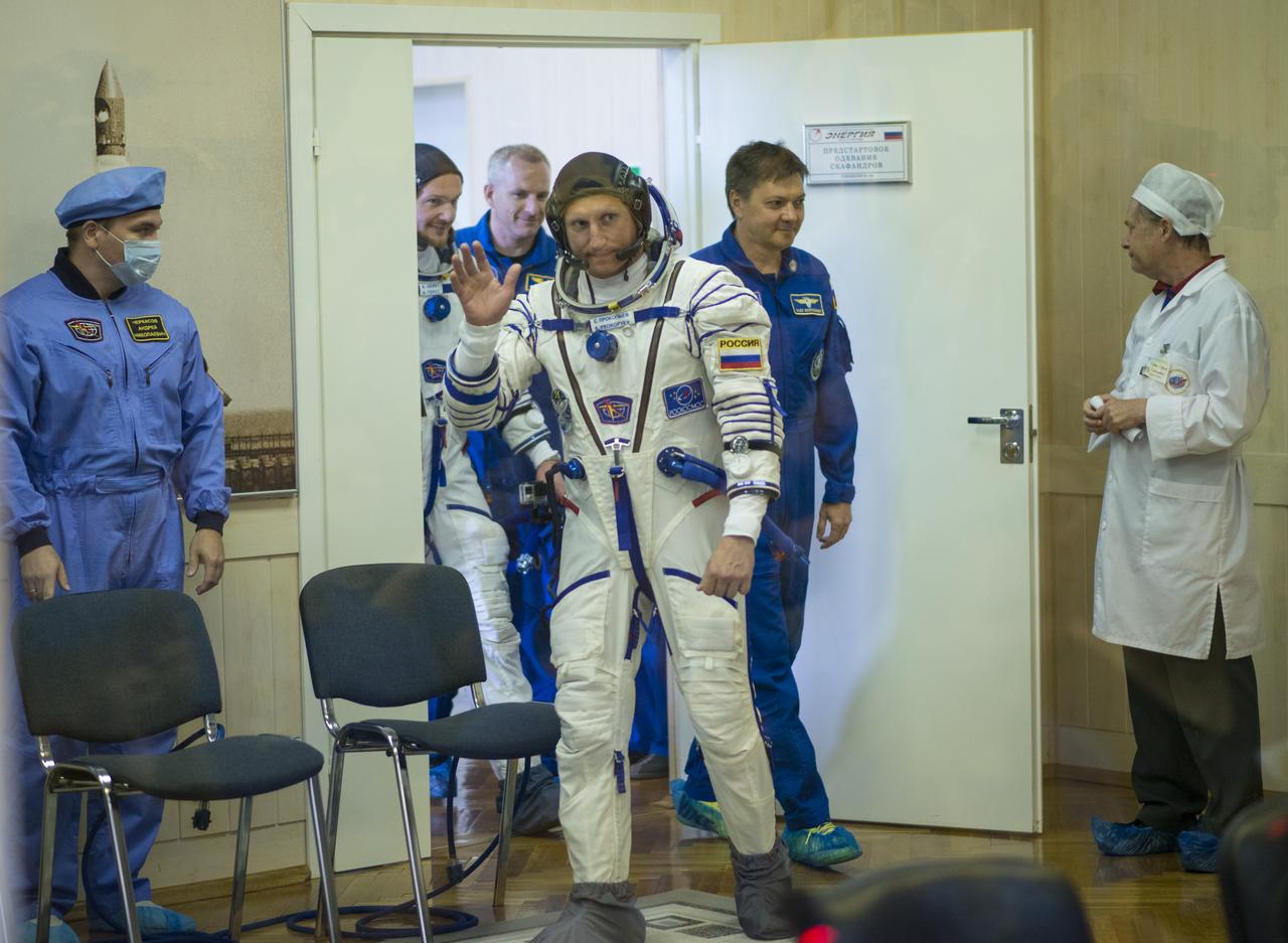 Expedition 56 Soyuz Commander Sergey Prokopyev of Roscosmos waves to family and friends as he prepares to have his Russian Sokol suit pressure checked in preparation for launch aboard the Soyuz MS-09 spacecraft, Wednesday, June 6, 2018 at the Baikonur Cosmodrome in Kazakhstan. Launch of the Soyuz rocket will send Prokopyev, Serena Auñón-Chancellor of NASA, and Alexander Gerst of ESA (European Space Agency) on a six month mission aboard the International Space Station.  Photo Credit: (NASA/Joel Kowsky)