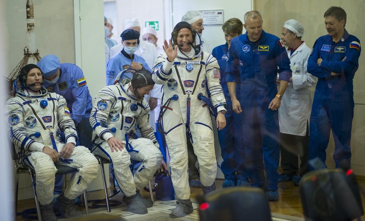 Expedition 56 flight engineer Serena Auñón-Chancellor of NASA waves to family and friends as she prepares to have her Russian Sokol suit pressure checked in preparation for launch aboard the Soyuz MS-09 spacecraft, Wednesday, June 6, 2018 at the Baikonur Cosmodrome in Kazakhstan. Launch of the Soyuz rocket will send Auñón-Chancellor, Sergey Prokopyev of Roscosmos, and Alexander Gerst of ESA (European Space Agency) on a six month mission aboard the International Space Station.  Photo Credit: (NASA/Joel Kowsky)