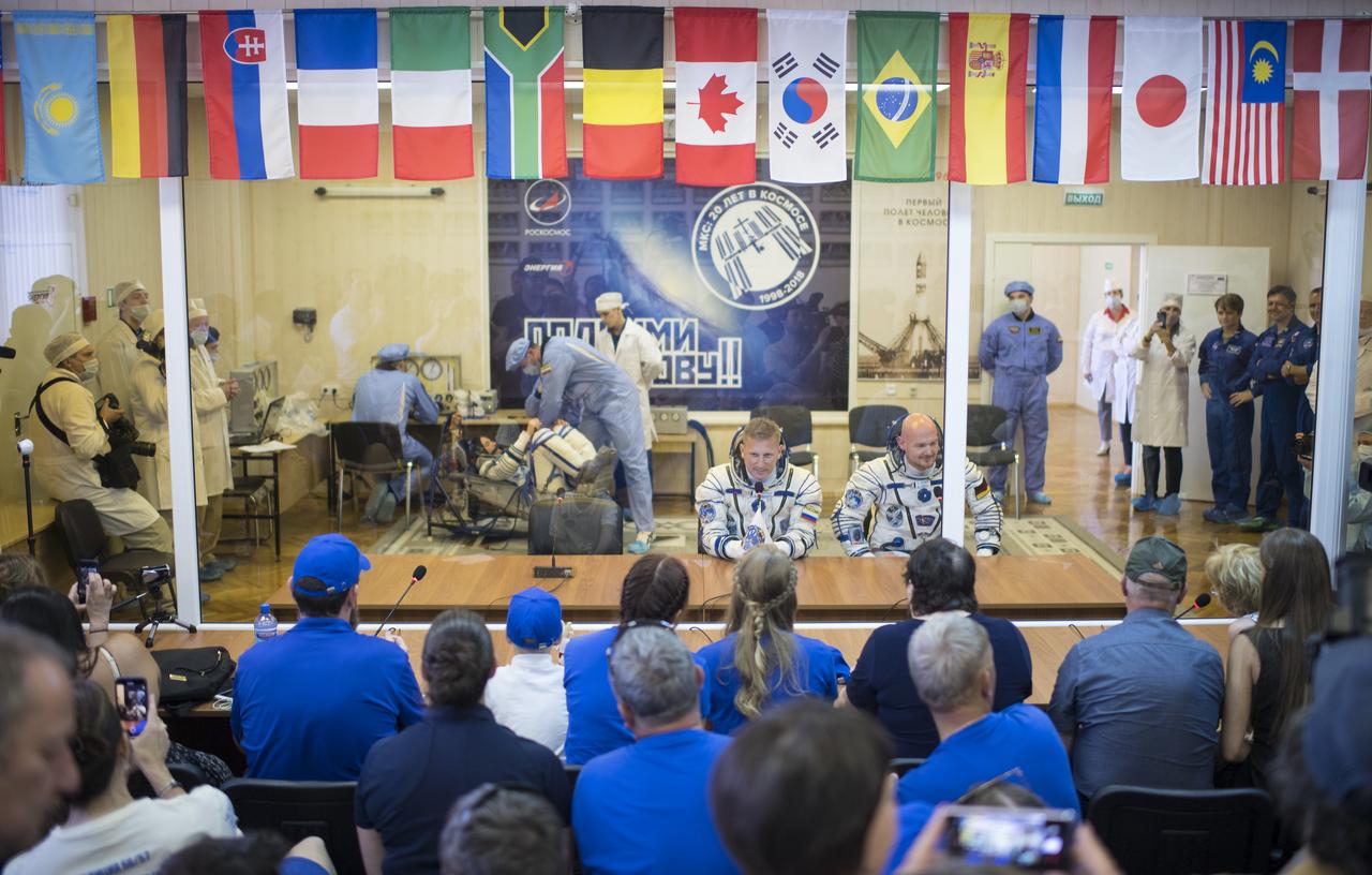 Expedition 56 flight engineer Serena Auñón-Chancellor of NASA, left, prepares to have her Russian Sokol suit pressure checked in preparation for launch aboard the Soyuz MS-09 spacecraft as Soyuz Commander Sergey Prokopyev of Roscosmos and flight engineer Alexander Gerst of ESA (European Space Agency) talk with family and friends, Wednesday, June 6, 2018 at the Baikonur Cosmodrome in Kazakhstan. Auñón-Chancellor, Prokopyev, and Gerst launched aboard the Soyuz MS-09 spacecraft at 7:12am EDT (5:12pm Baikonur time) on June 6 to begin their journey to the International Space Station.  Photo Credit: (NASA/Joel Kowsky)