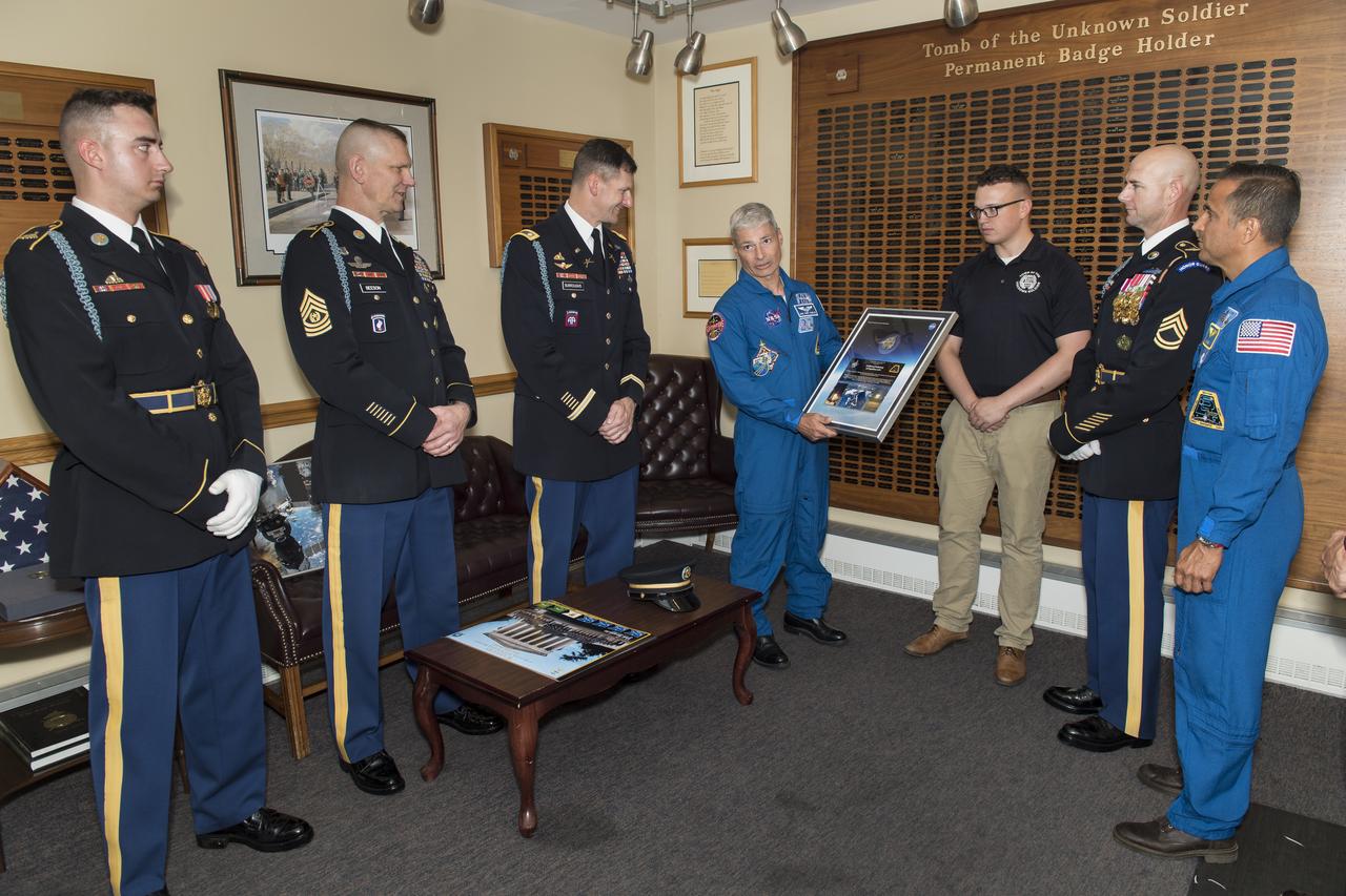 NASA astronauts Mark Vande Hei, center, and Joe Acaba, right, present Lieutenant Colonel Jeffery Todd Burroughs, battalion commander, Old Guard, and others from the Honor Guard with their patch that was flown onboard the International Space Station during Expedition 54, Friday, June 15, 2018 at the Arlington National Cemetery in Arlington, Va. Photo Credit: (NASA/Aubrey Gemignani)