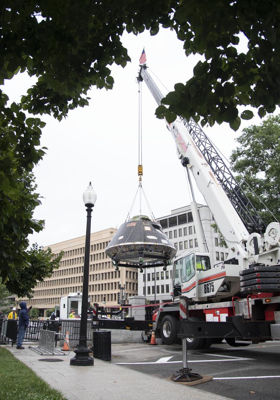 NASA's Orion spacecraft that flew Exploration Flight Test-1 on Dec. 5, 2014 is seen as it is lifted over a gate onto the White House complex, Saturday, July 21, 2018 in Washington, DC. Lockheed Martin, NASA’s prime contractor for Orion, began manufacturing the Orion crew module in 2011 and delivered it in July 2012 to NASA's Kennedy Space Center where final assembly, integration and testing was completed. More than 1,000 companies across the country manufactured or contributed elements to the spacecraft. Photo Credit: (NASA/Joel Kowsky)