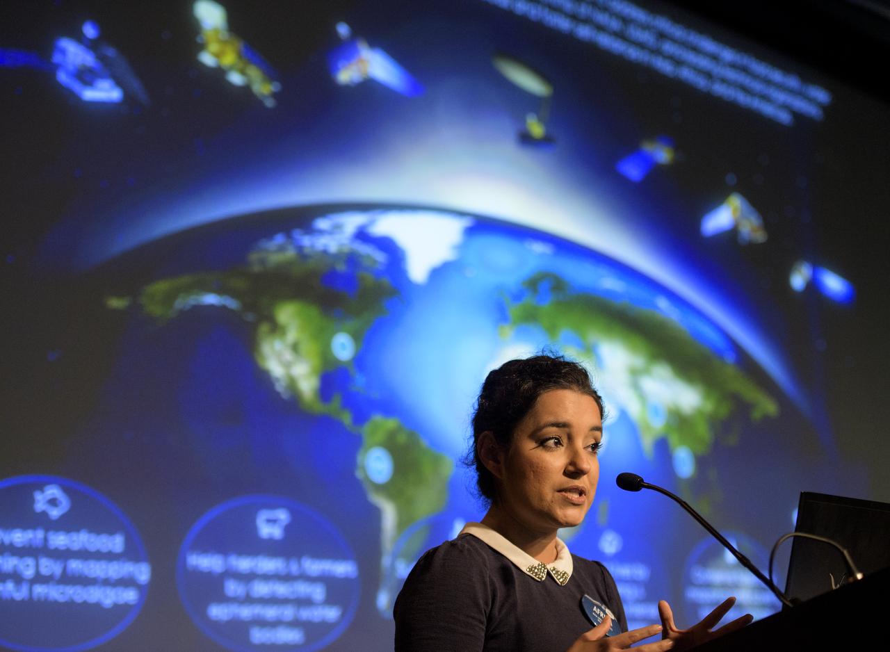 Africa Flores, Land Cover and Land Use Change Theme Lead for SERVIR, speaks during the 2018 Annual Earth Science Applications Showcase, Wednesday, Aug. 1, 2018 at NASA Headquarters in Washington. Every summer students and young professionals from NASA’s Applied Sciences’ DEVELOP National Program come to NASA Headquarters and present their research projects. DEVELOP is a training and development program where students work on Earth science research projects, mentored by science advisers from NASA and partner agencies, and extend research results to local communities.  Photo Credit: (NASA/Joel Kowsky)