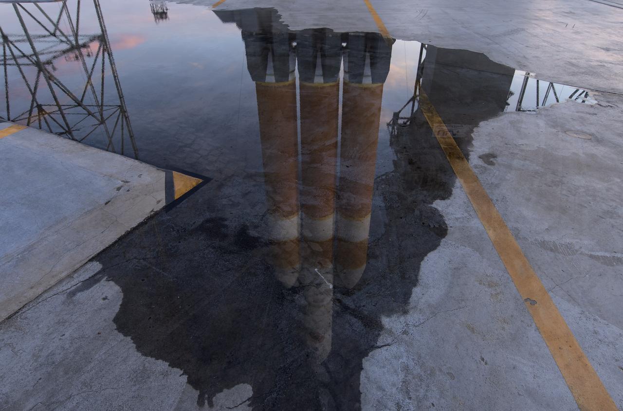 The United Launch Alliance Delta IV Heavy rocket with the Parker Solar Probe onboard is seen refelcted in water shortly after the Mobile Service Tower was  rolled back, Friday, Aug. 10, 2018, Launch Complex 37 at Cape Canaveral Air Force Station in Florida. Parker Solar Probe is humanity’s first-ever mission into a part of the Sun’s atmosphere called the corona.  Here it will directly explore solar processes that are key to understanding and forecasting space weather events that can impact life on Earth. Photo Credit: (NASA/Bill Ingalls)