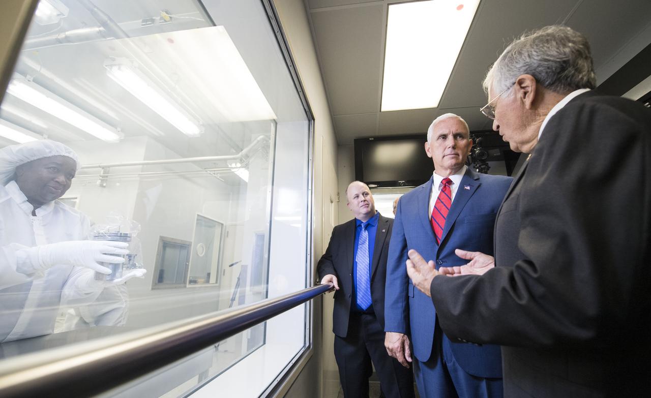 Vice President Mike Pence, center, views Sample 15014, which was collected during Apollo 15 with NASA's Apollo Sample Curator Ryan Zeigler, left, and Apollo 17 astronaut and geologist Dr. Harrison Schmitt, right, in Lunar Curation Laboratory at NASA's Johnson Space Center, Thursday, Aug. 23, 2018 in Houston, Texas. Sample 15014 is one of nine samples out of the 2,196 collected during the Apollo missions that was sealed inside its container on the Moon and still containes gasses from the Moon. Photo Credit: (NASA/Joel Kowsky)