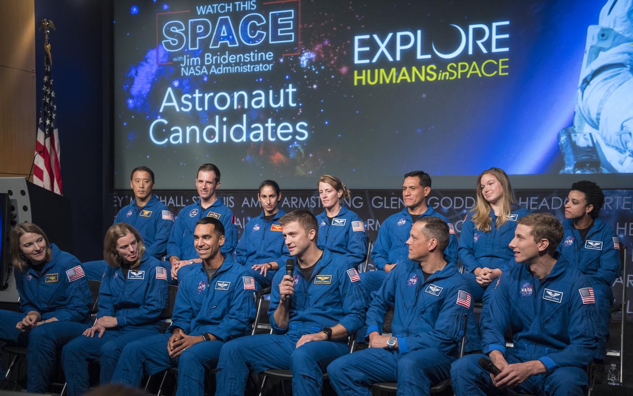 NASA astronaut candidate Matthew Dominick, third from right in the front row, answers a question during a live episode of the Administrator's monthly chat show, Watch This Space, along with fellow members of the 2017 astronaut candidate class, Thursday, Sept. 27, 2018 in the Webb Auditorium at NASA Headquarters in Washington. NASA's newest astronaut candidate class has started their two years of training, after which the new astronaut candidates could be assigned to missions performing research on the International Space Station, launching from American soil on spacecraft built by commercial companies, and launching on deep space missions on NASA’s new Orion spacecraft and Space Launch System rocket.  Photo Credit: (NASA/Joel Kowsky)