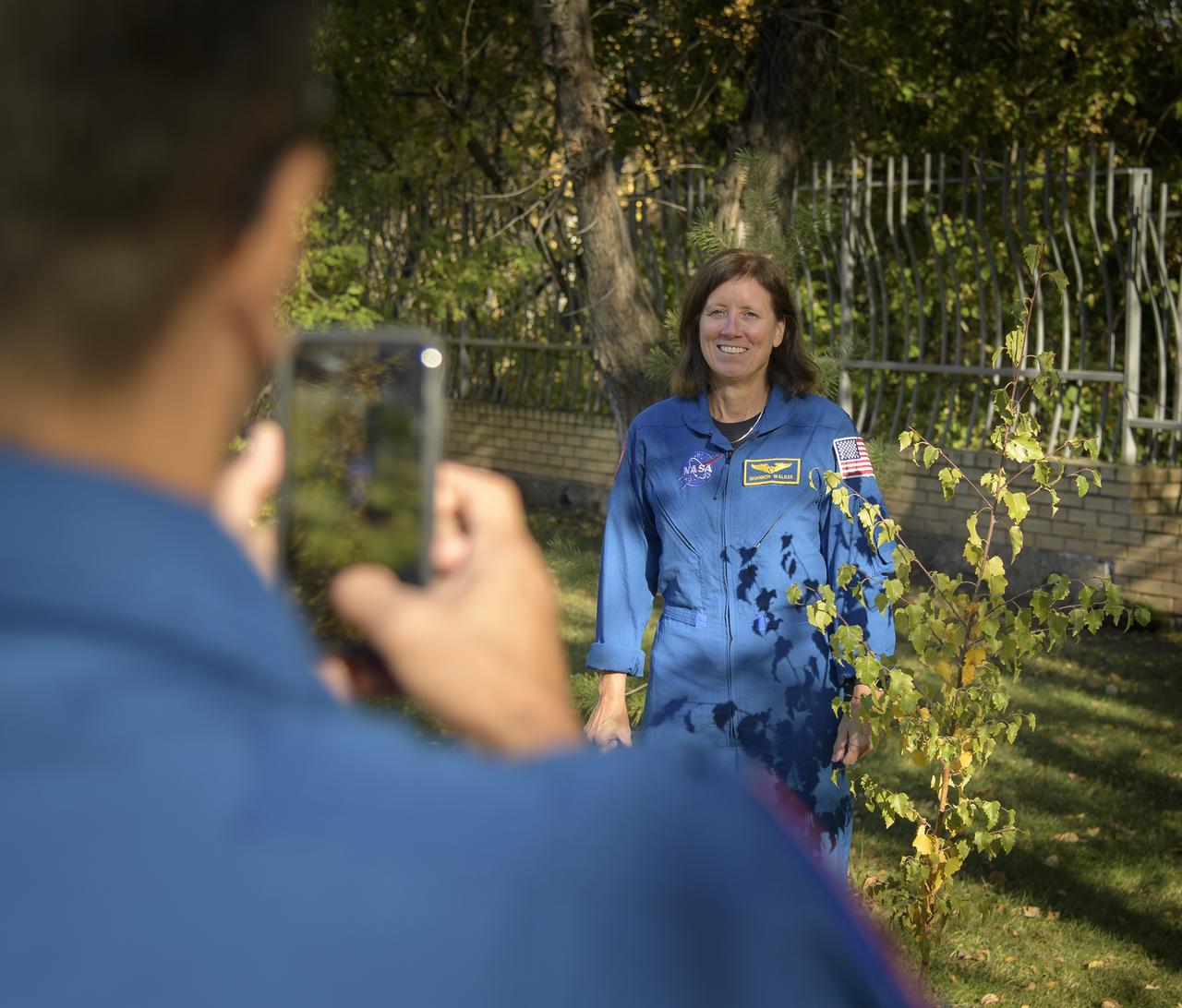NASA astronaut and Director of Operations, Star City, Russia, Joe Acaba takes a photograph of NASA astronaut and Astronaut Office Representative Shannon Walker after they each planted a tree during a traditional ceremony at the Cosmonaut Hotel in Karaganda, Kazakhstan, Tuesday, Oct. 2, 2018. Acaba and Walker are in Karaganda to help support the Expedition 56 crew Soyuz landing from the International Space Station. Photo Credit: (NASA/Bill Ingalls)